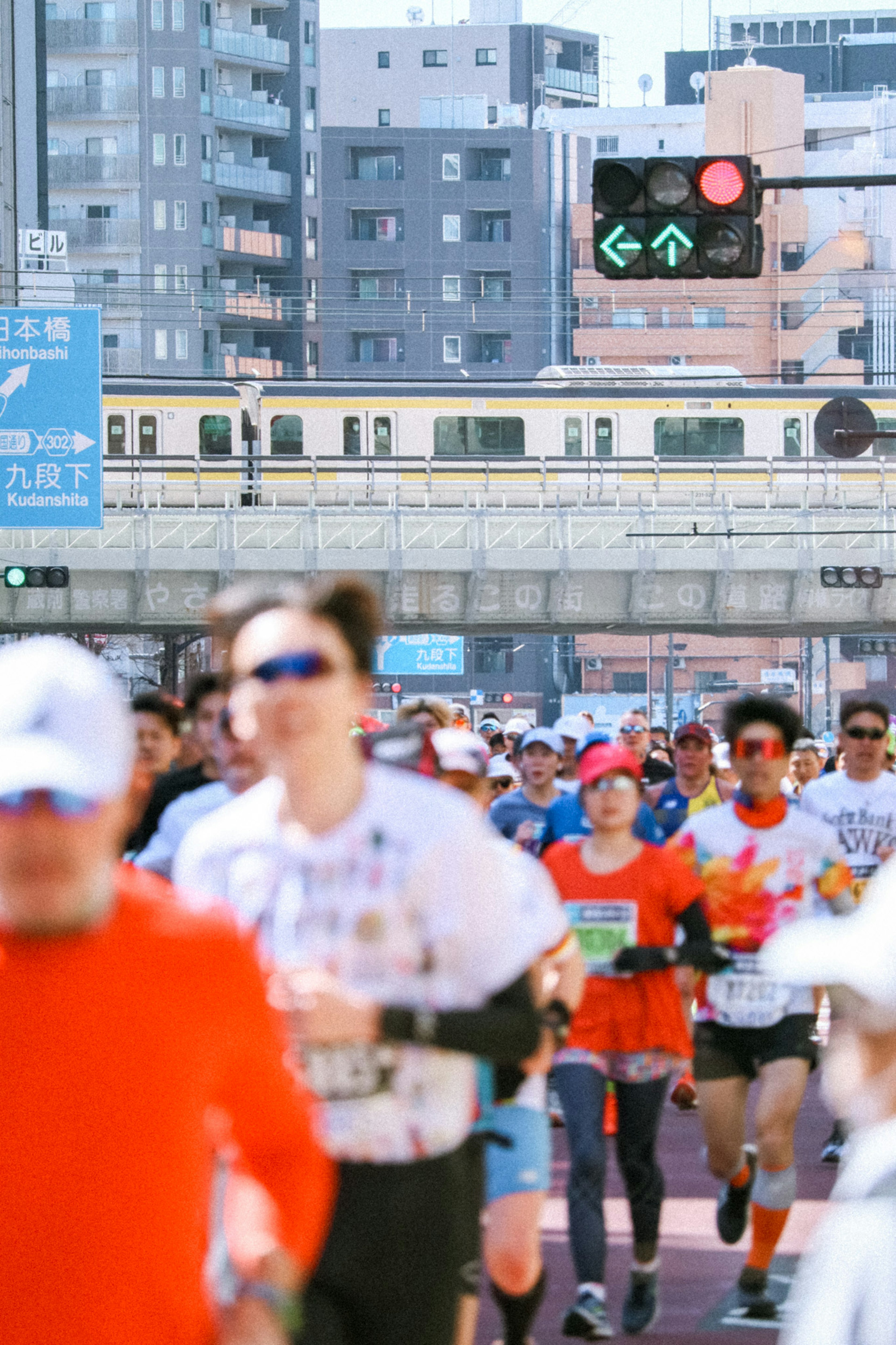 ランニングイベントの参加者が街中を走っている様子赤と白の服を着たランナー