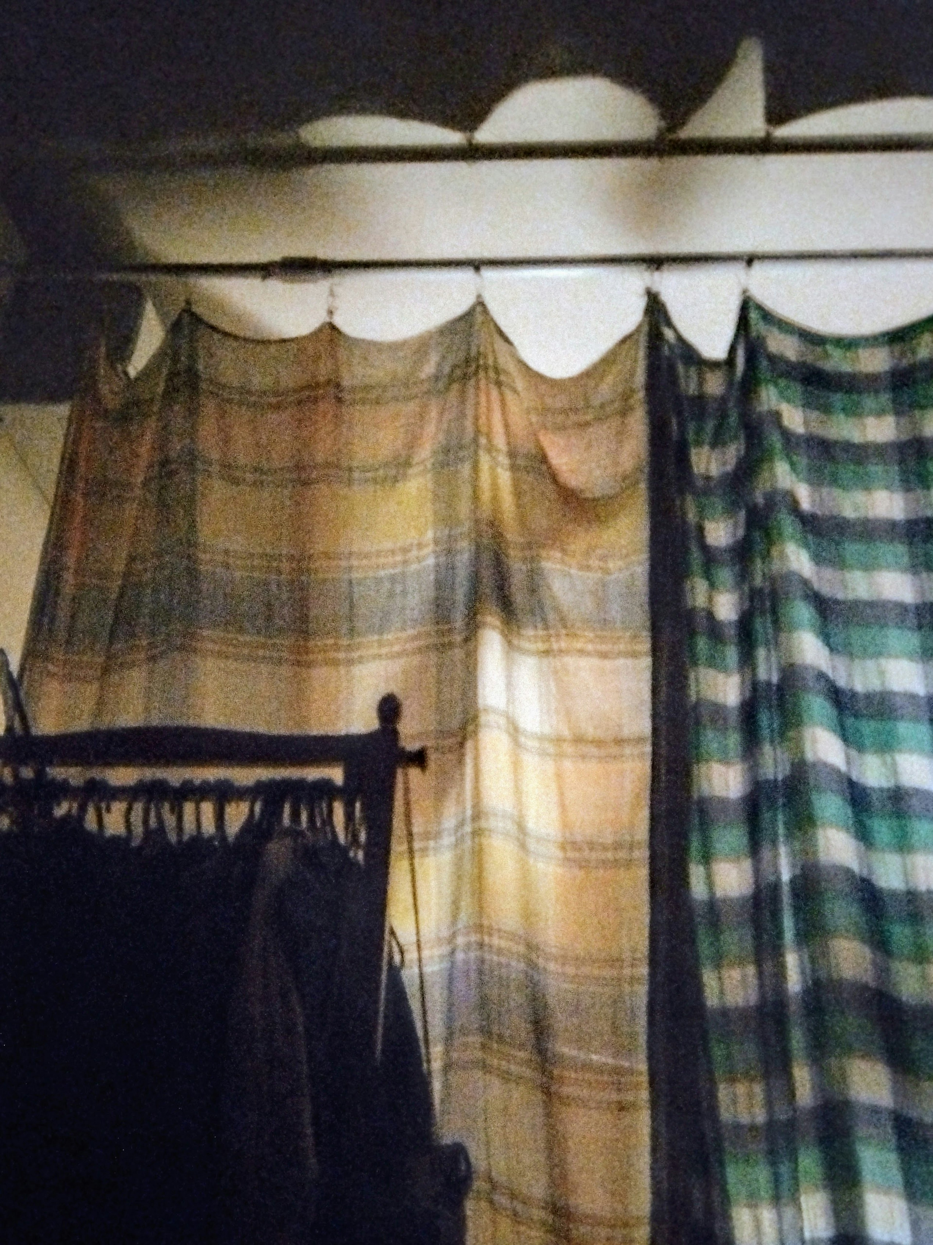 Silhouettes of clothing behind checkered fabric curtains