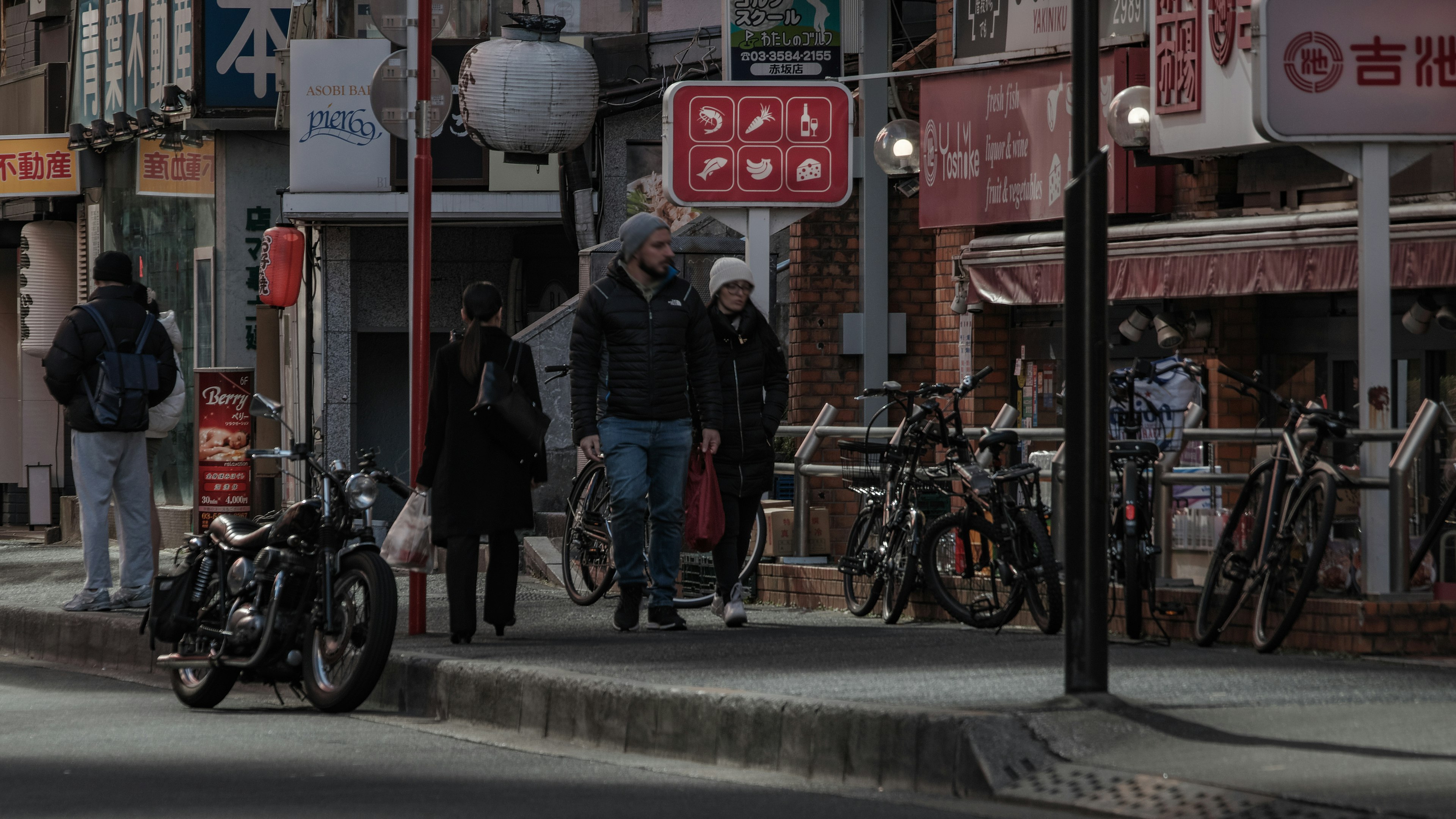 街の通りに立っている人々とバイクの風景