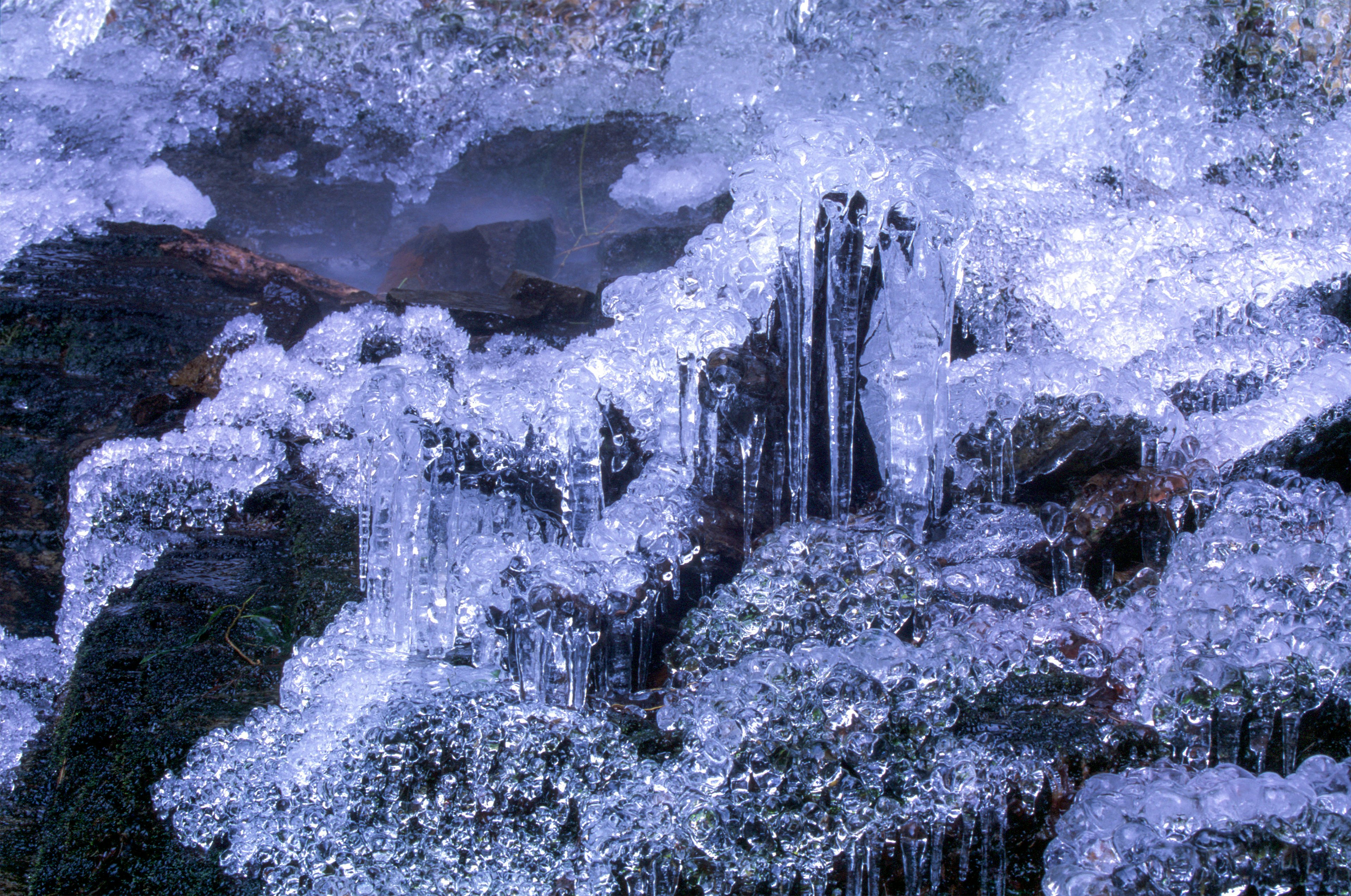 Eiskristalle bilden sich auf Steinen in einer Winterlandschaft