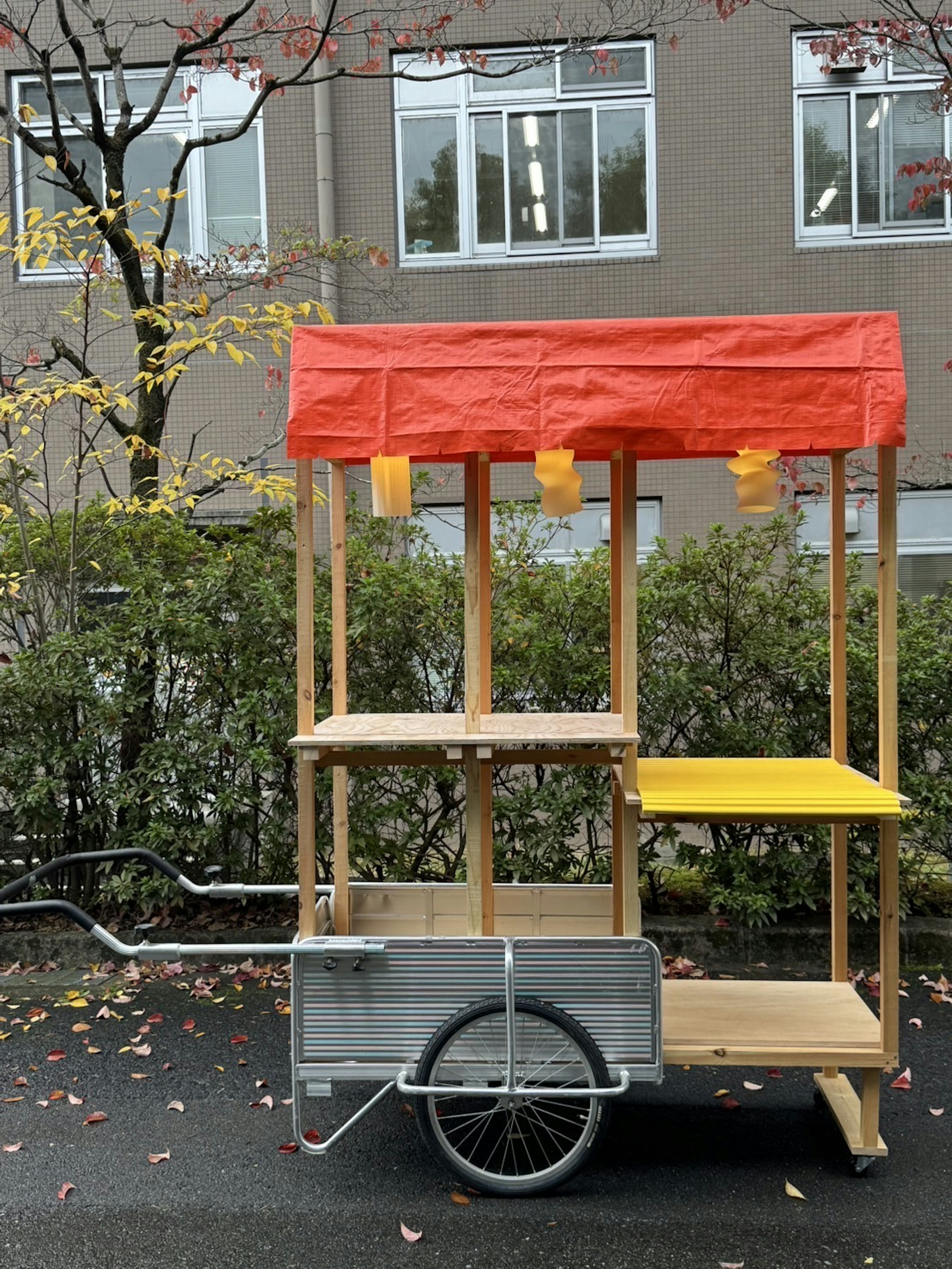 Carrello per cibo colorato con un tendone arancione e un tavolo giallo