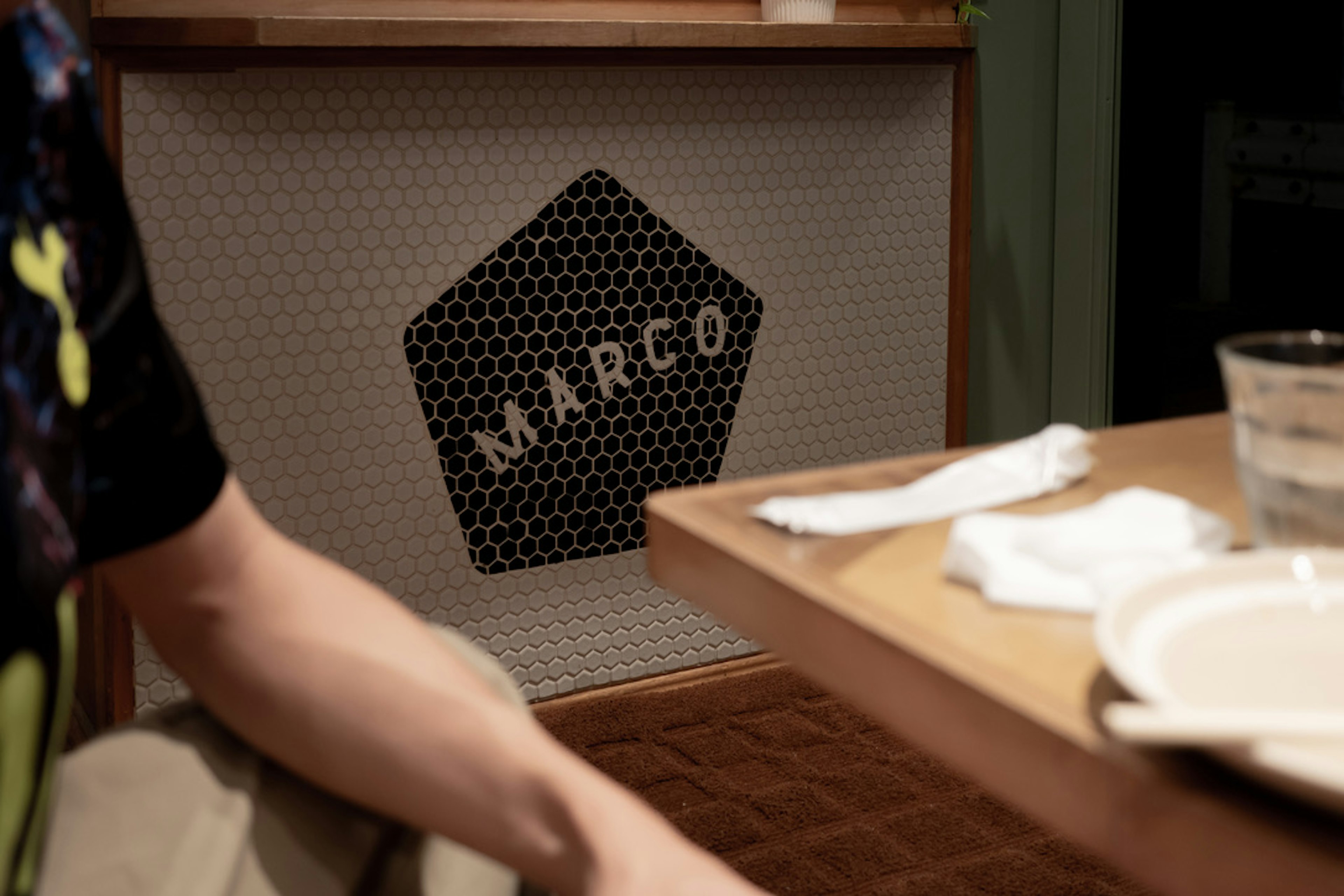 Person sitting at a table with a Marco logo in the background