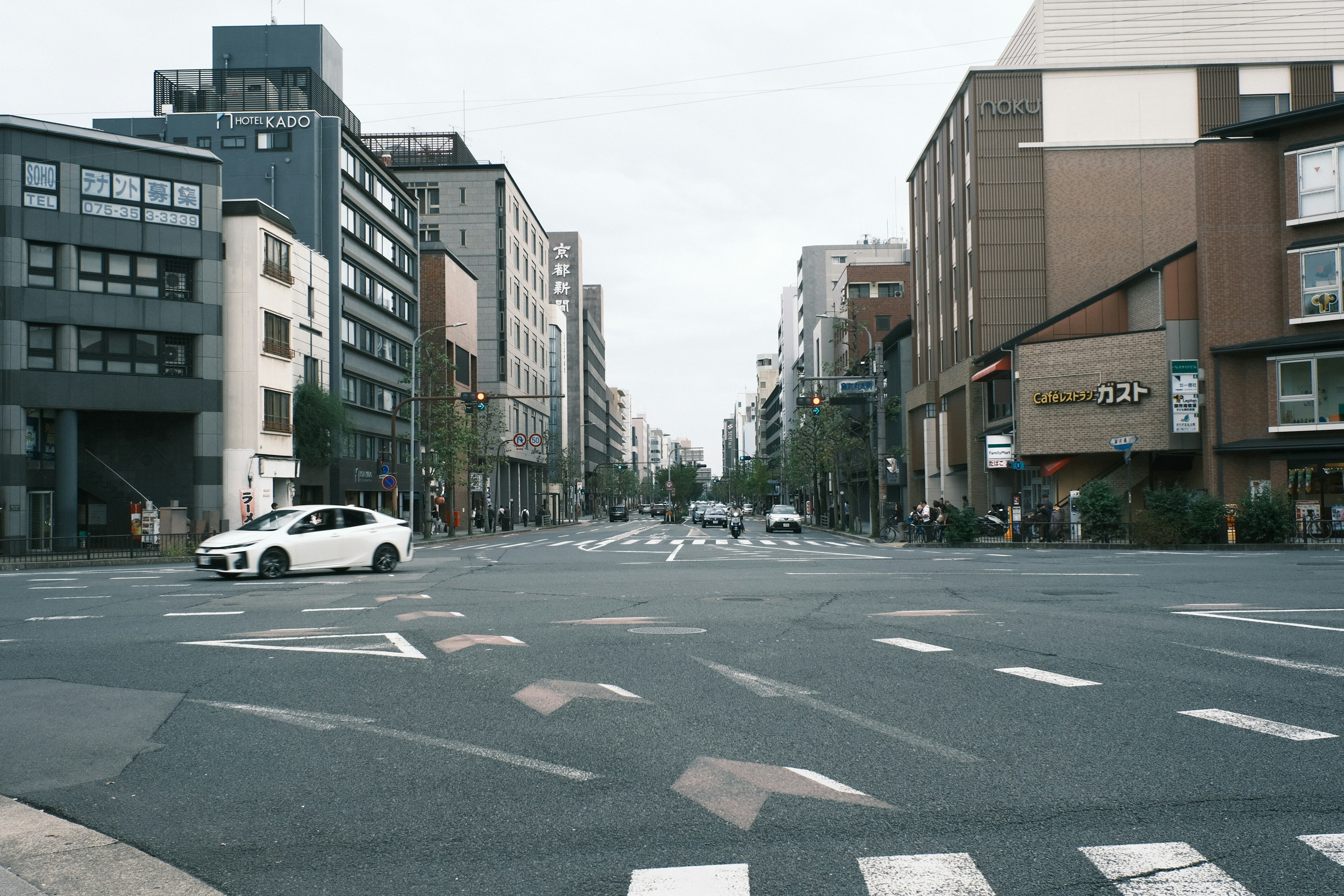 Intersection view featuring buildings and a white car