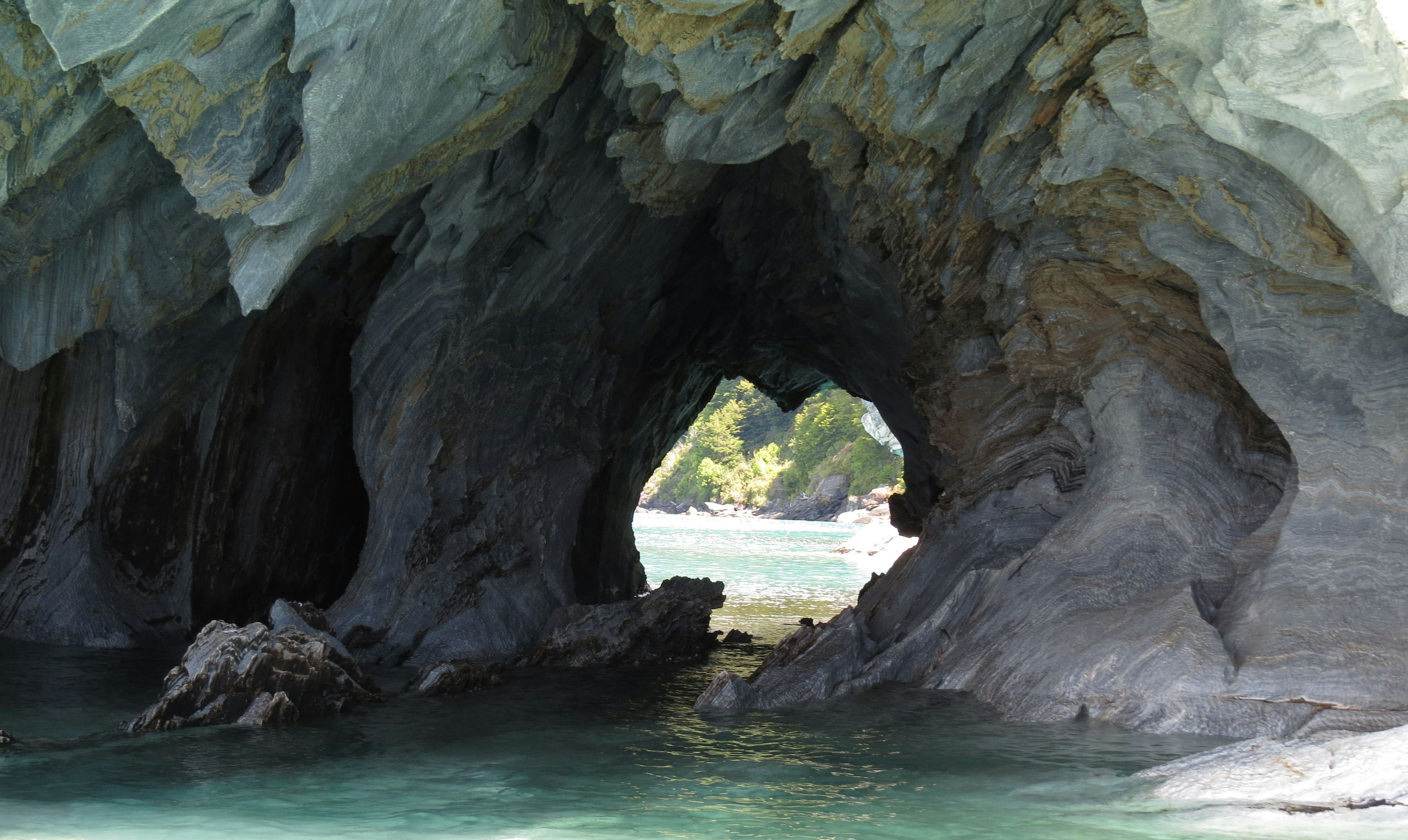 Tunnel di roccia circondato da acqua blu