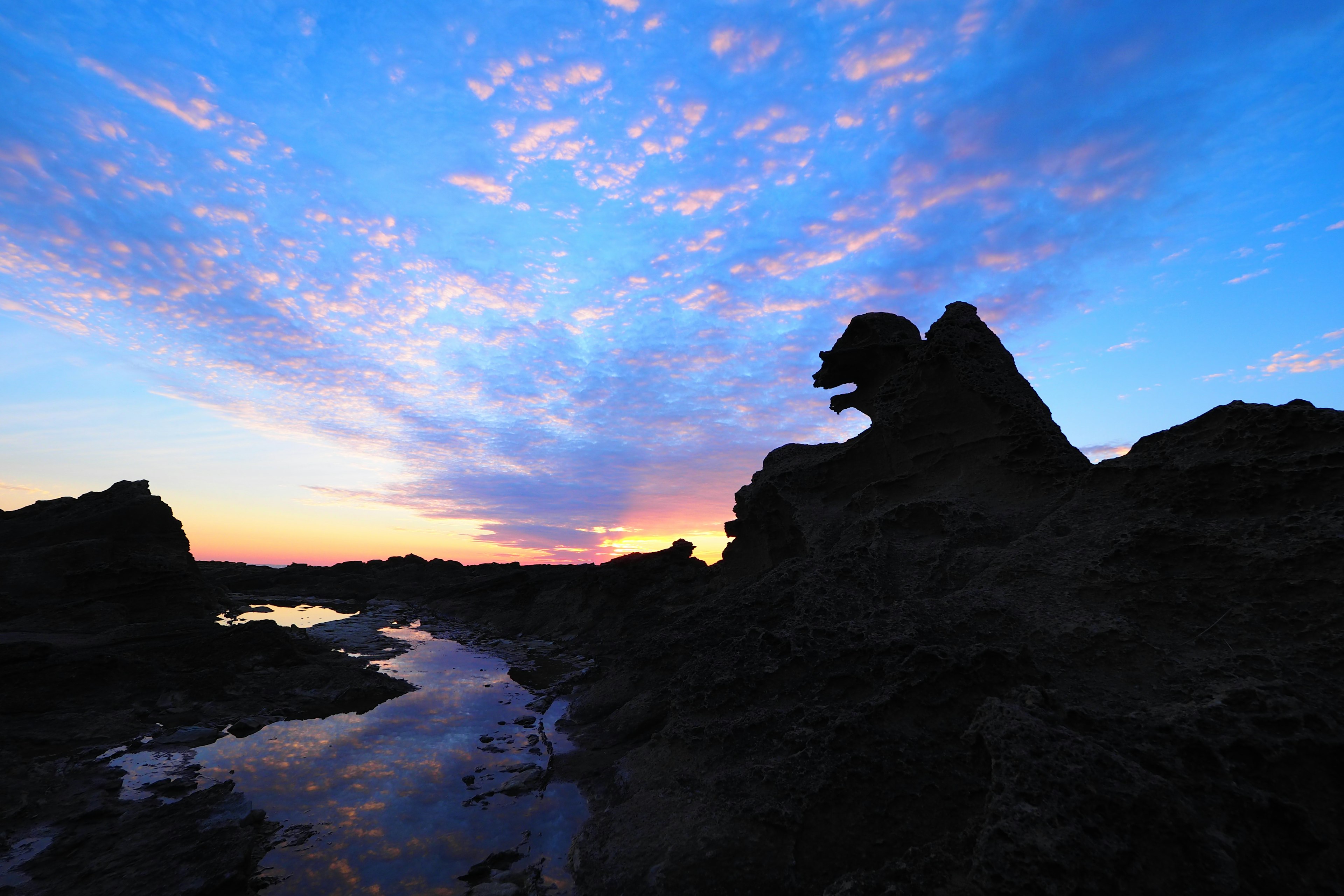 Siluet batu di latar belakang langit senja yang hidup