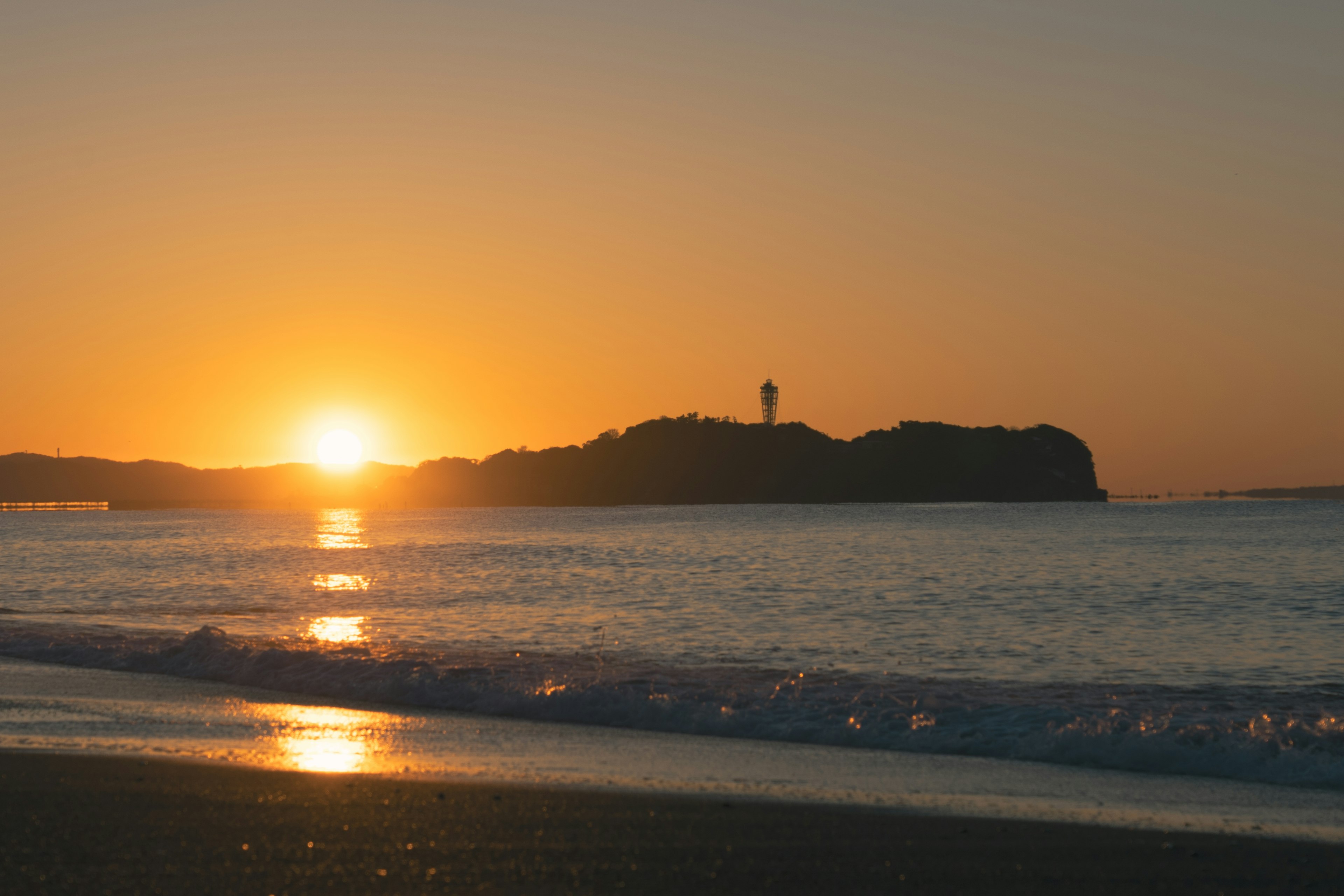 美麗的日落在海上與一個島嶼和燈塔