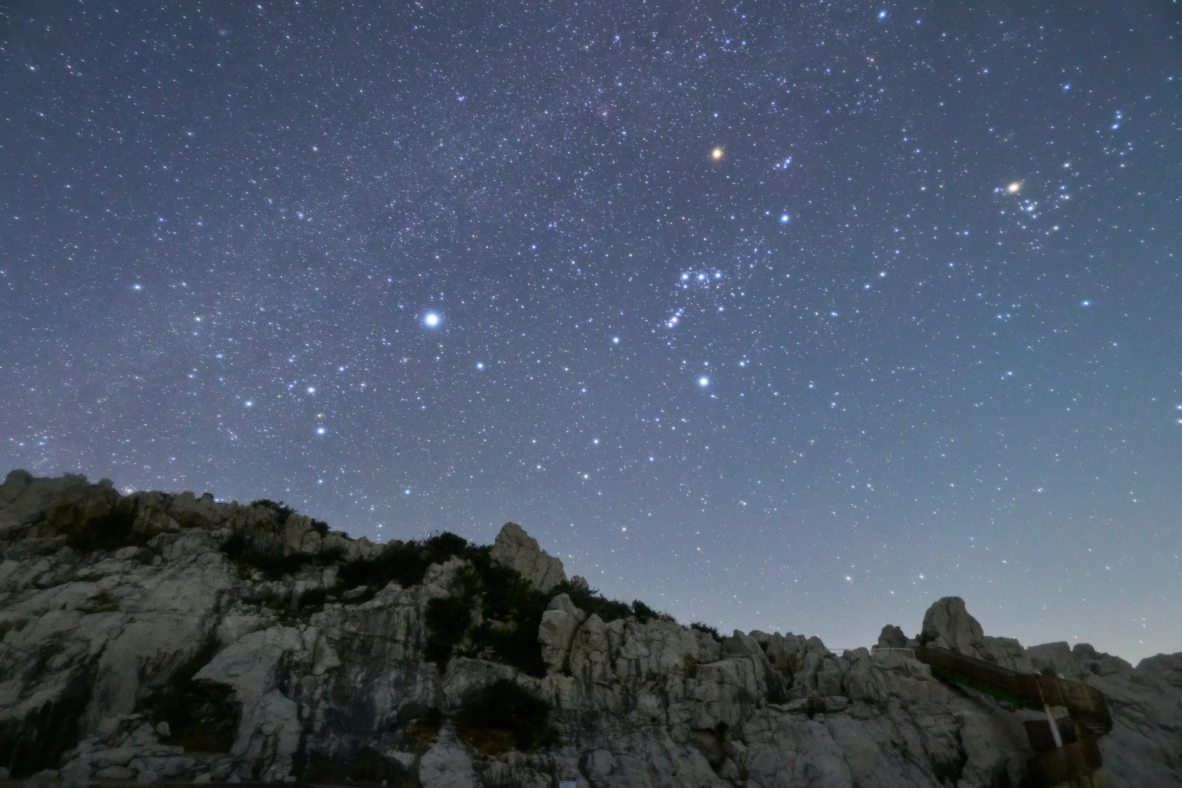 Impresionante cielo nocturno lleno de estrellas sobre un paisaje rocoso