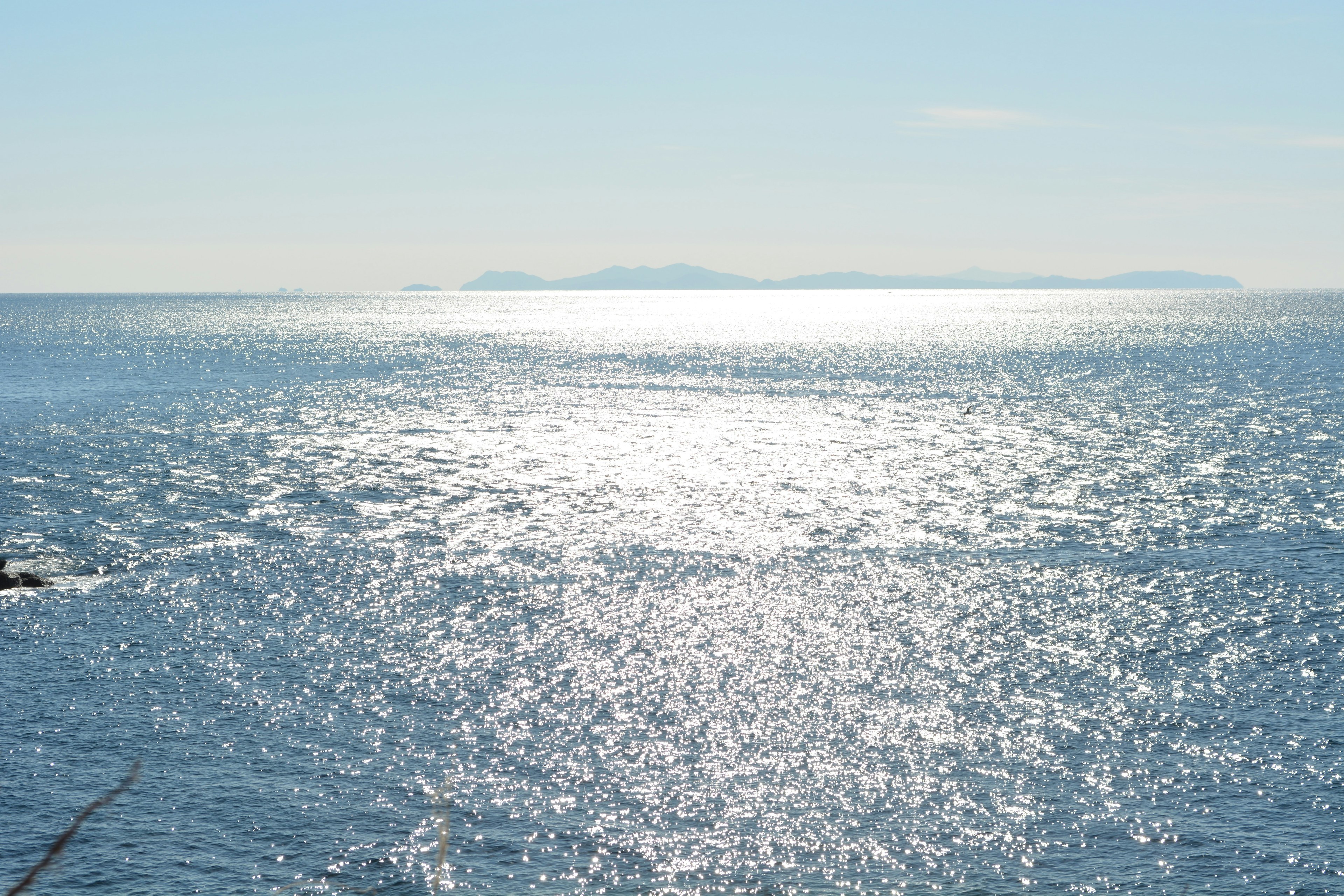 Ruhige Meereslandschaft mit blauem Wasser und Sonnenlicht, das auf der Oberfläche reflektiert