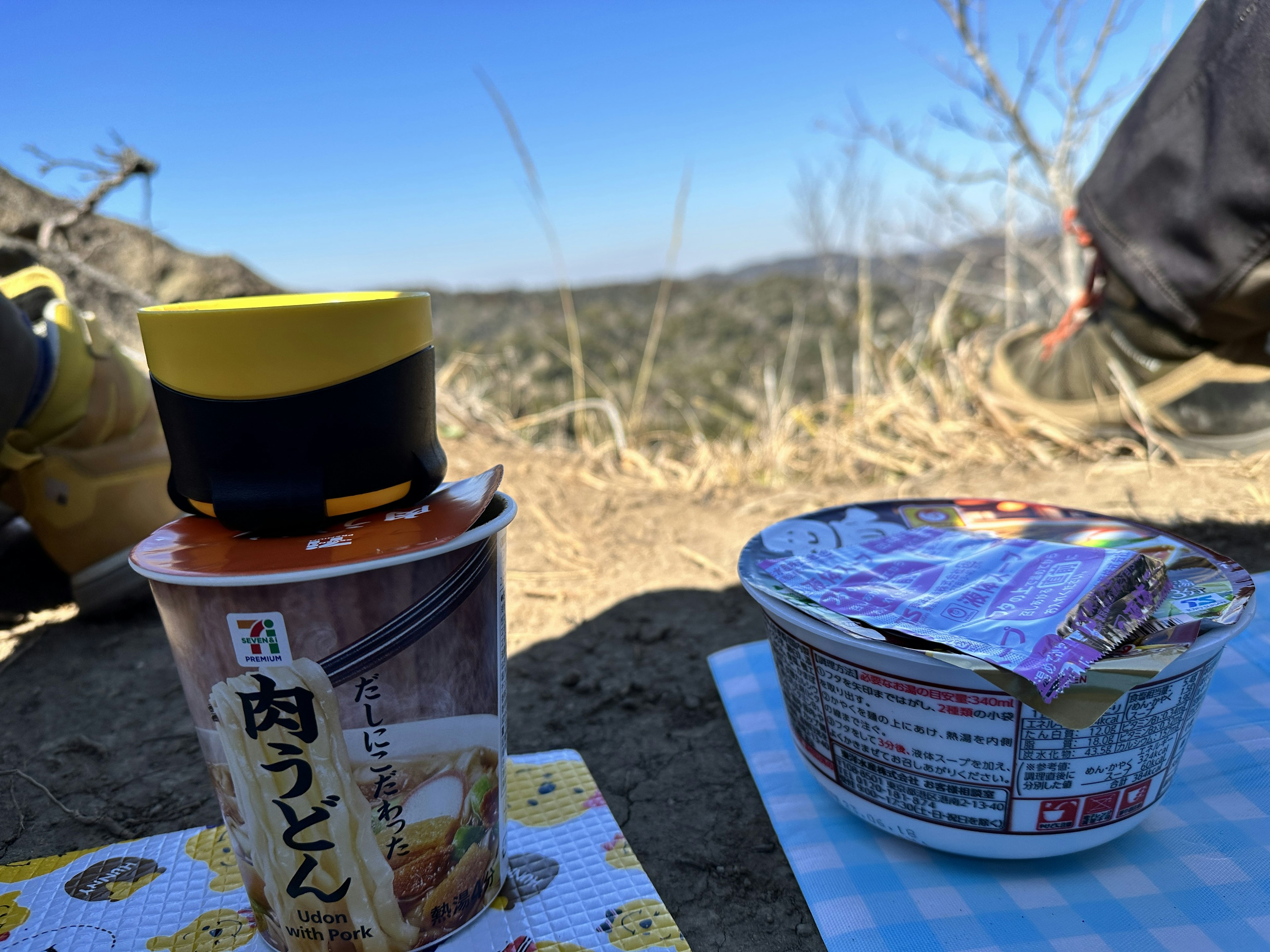 Picnic scene in the mountains featuring instant noodles and cup noodles