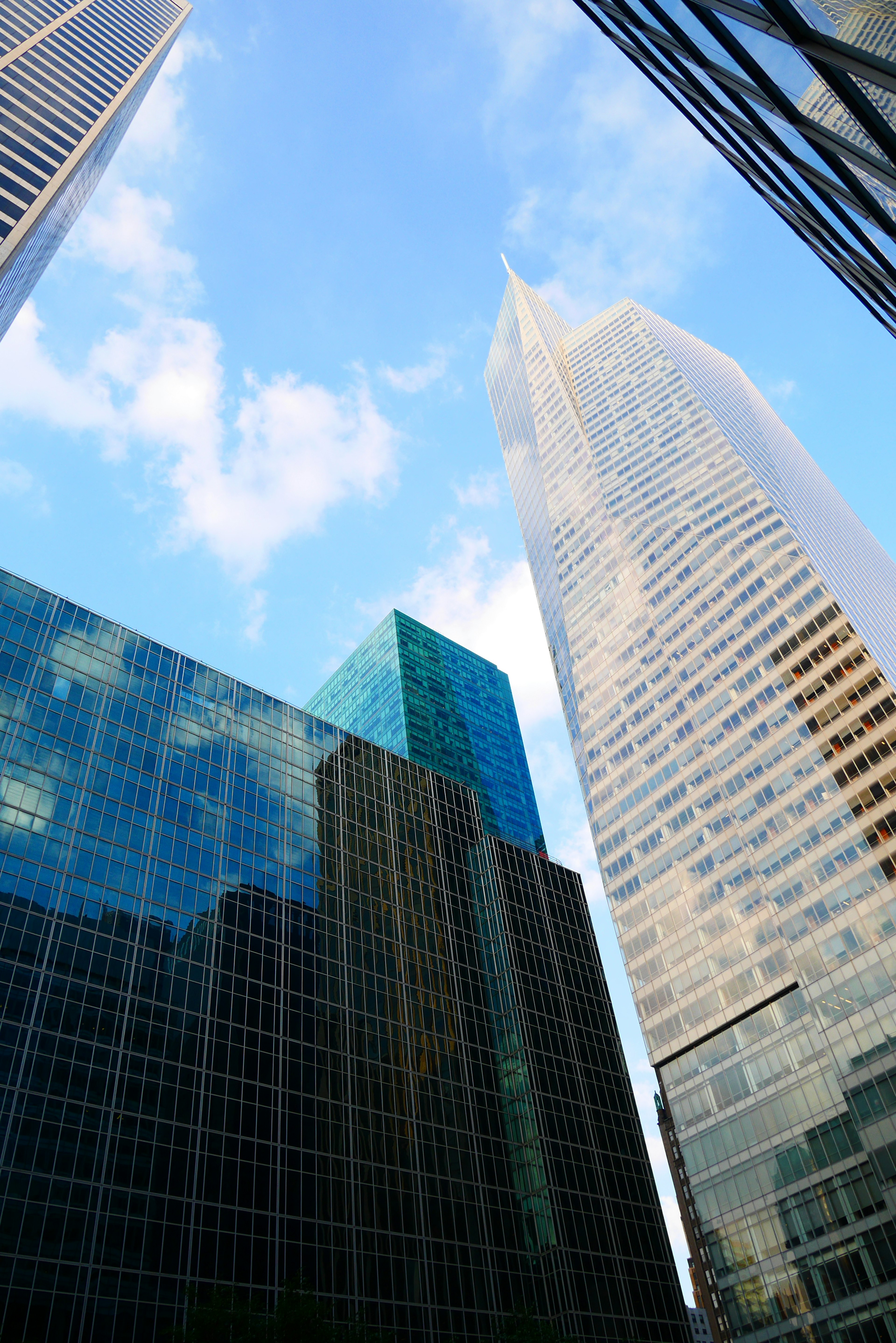 View of blue sky and clouds from between skyscrapers