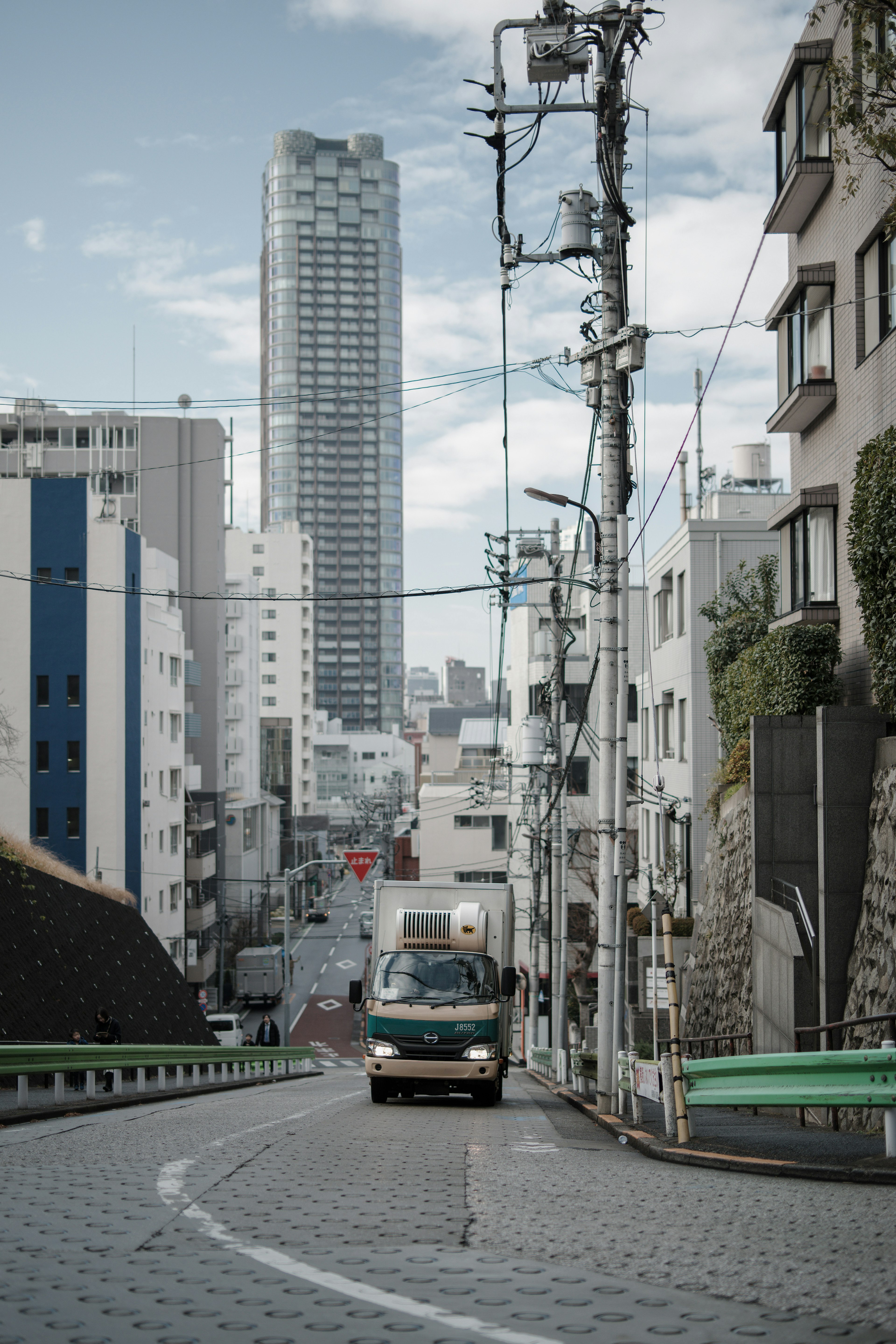 東京の都市景観に沿った曲がりくねった道を走るトラック