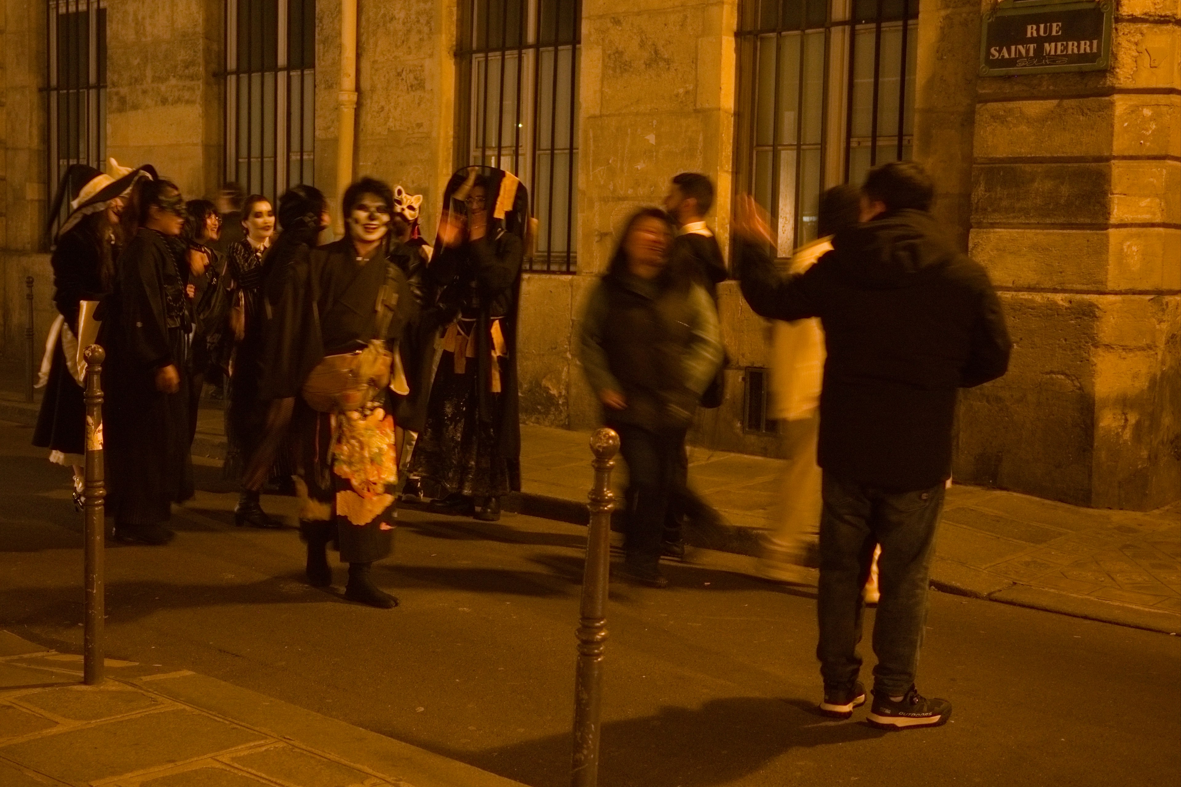 Una escena de personas disfrazadas reunidas en la calle por la noche