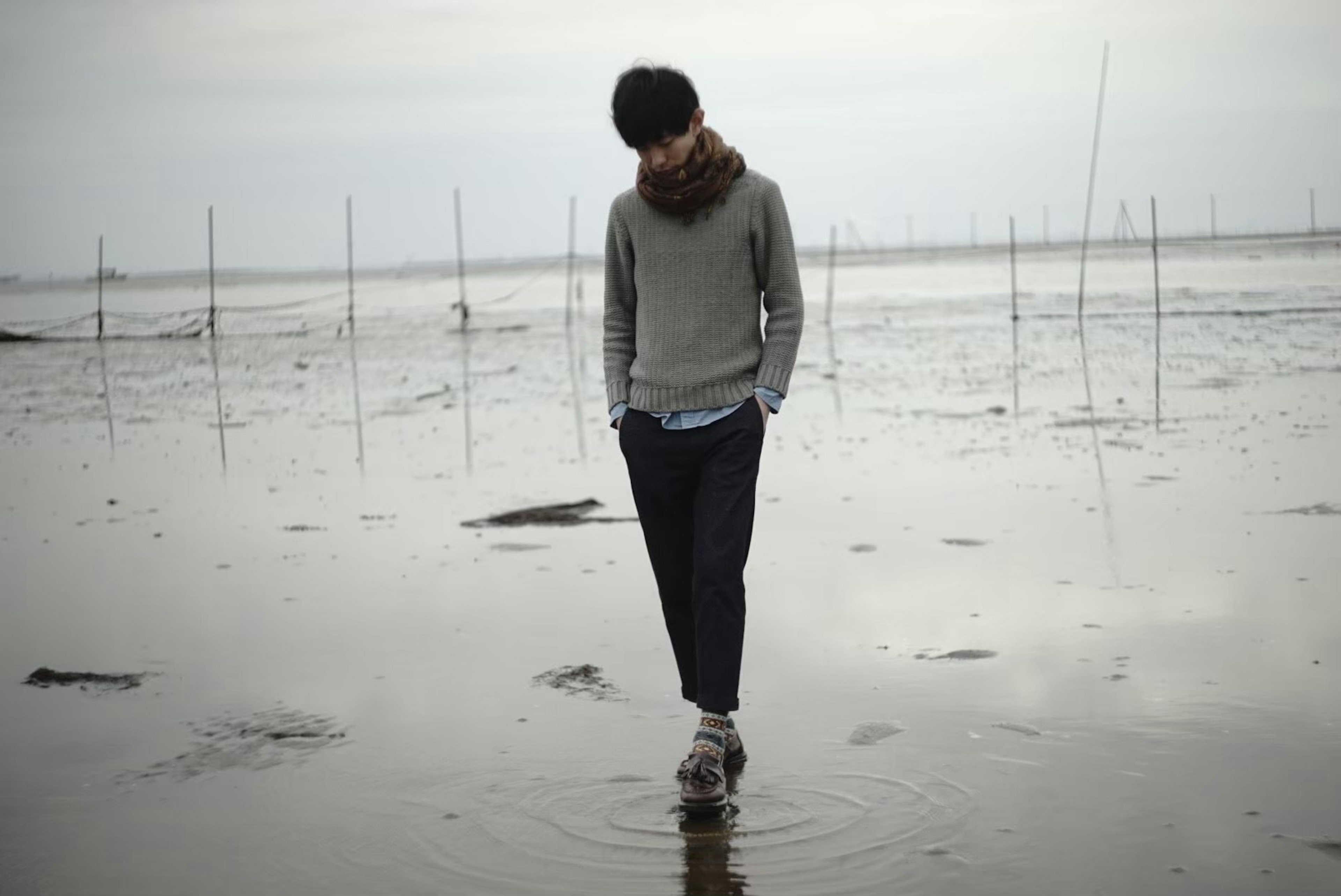 Hombre caminando por la playa con una atmósfera serena y un paisaje natural