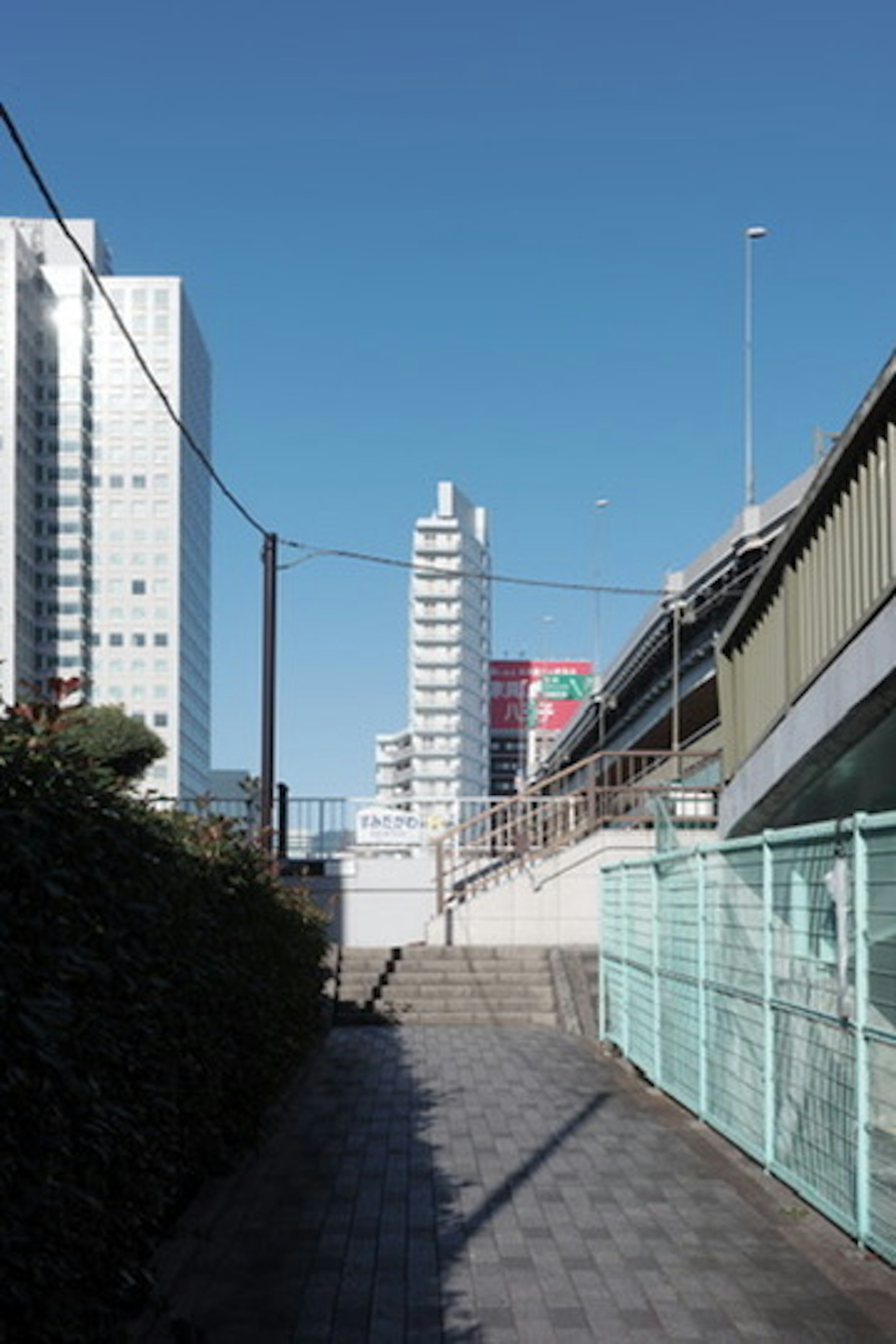 青空の下にある近代的な建物と歩道の風景