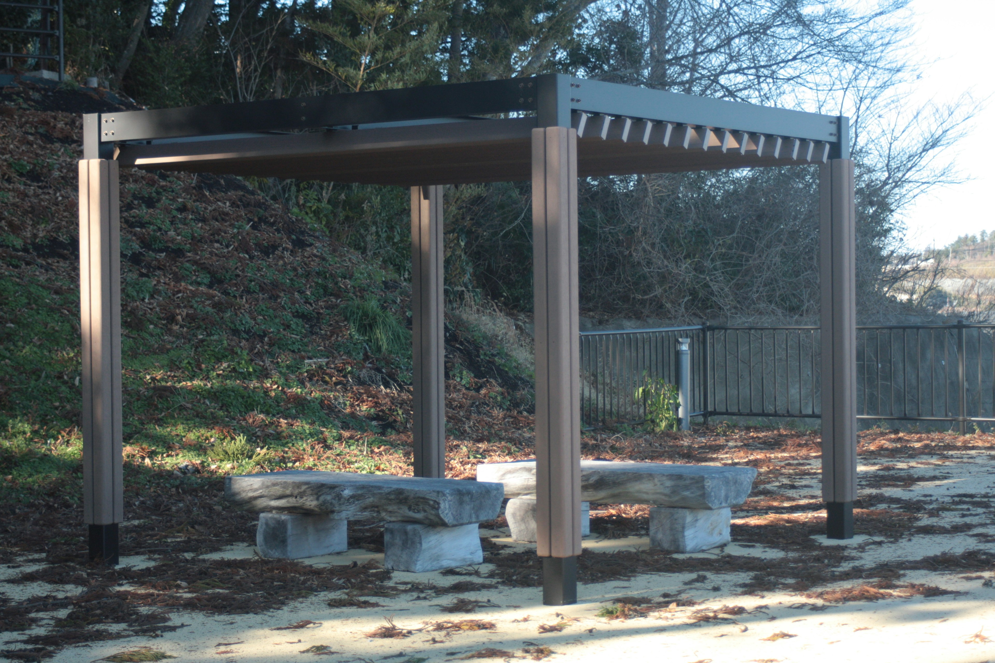 Gazebo de parque con bancos de piedra en un entorno natural