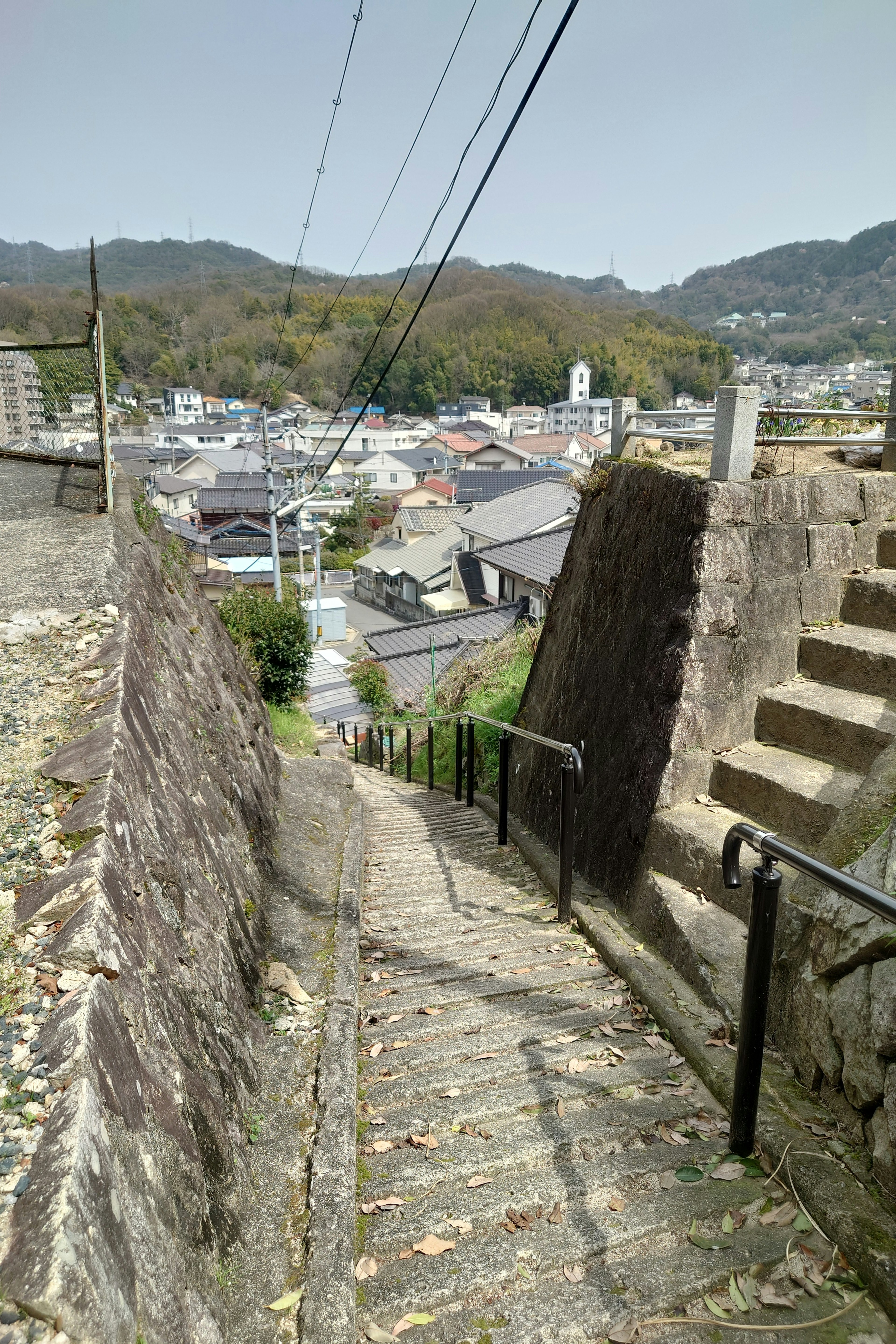 Escalier en pierre descendant avec vue sur une ville et des montagnes