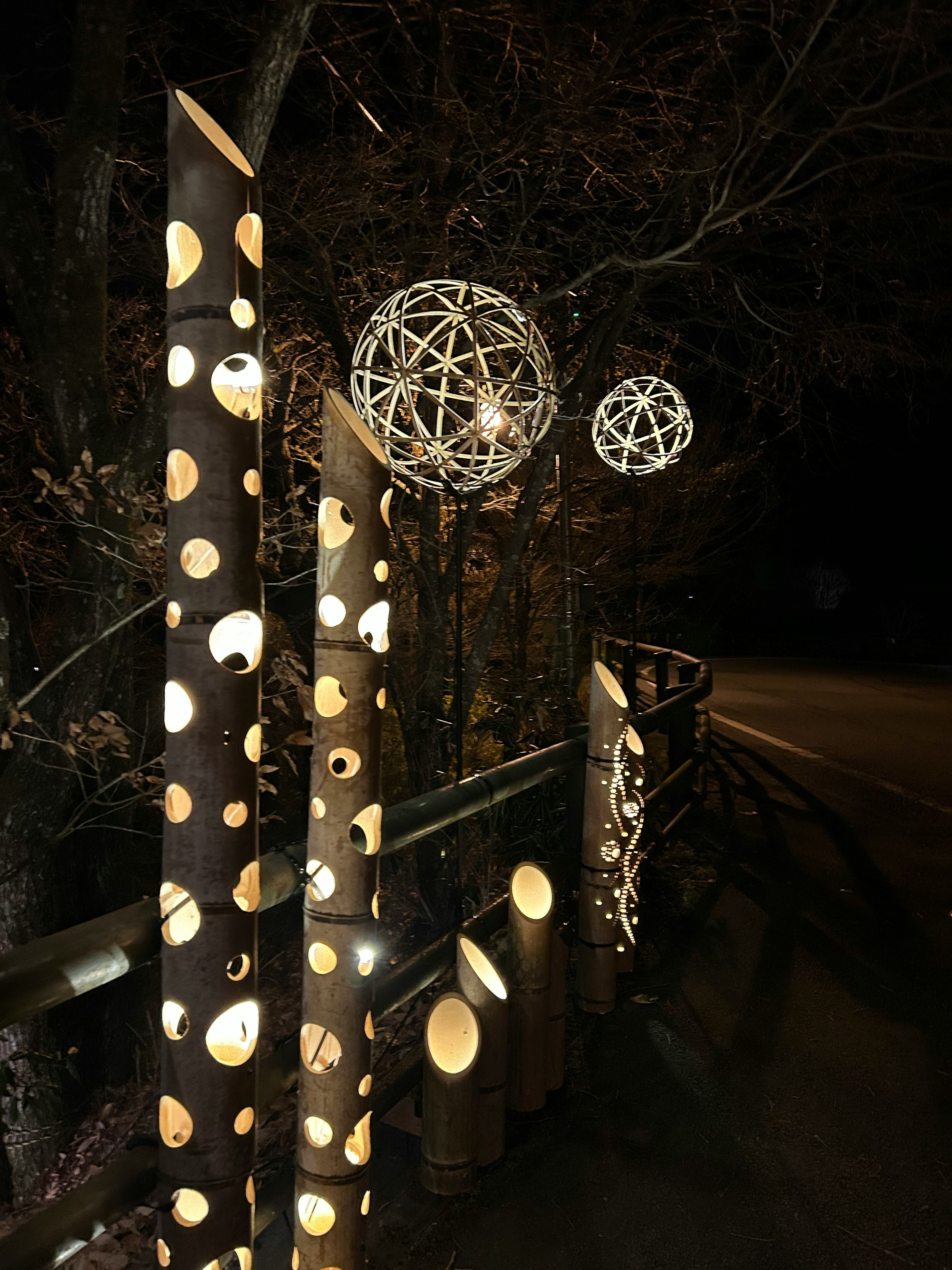 Postes de madera decorativos con esferas iluminadas de noche