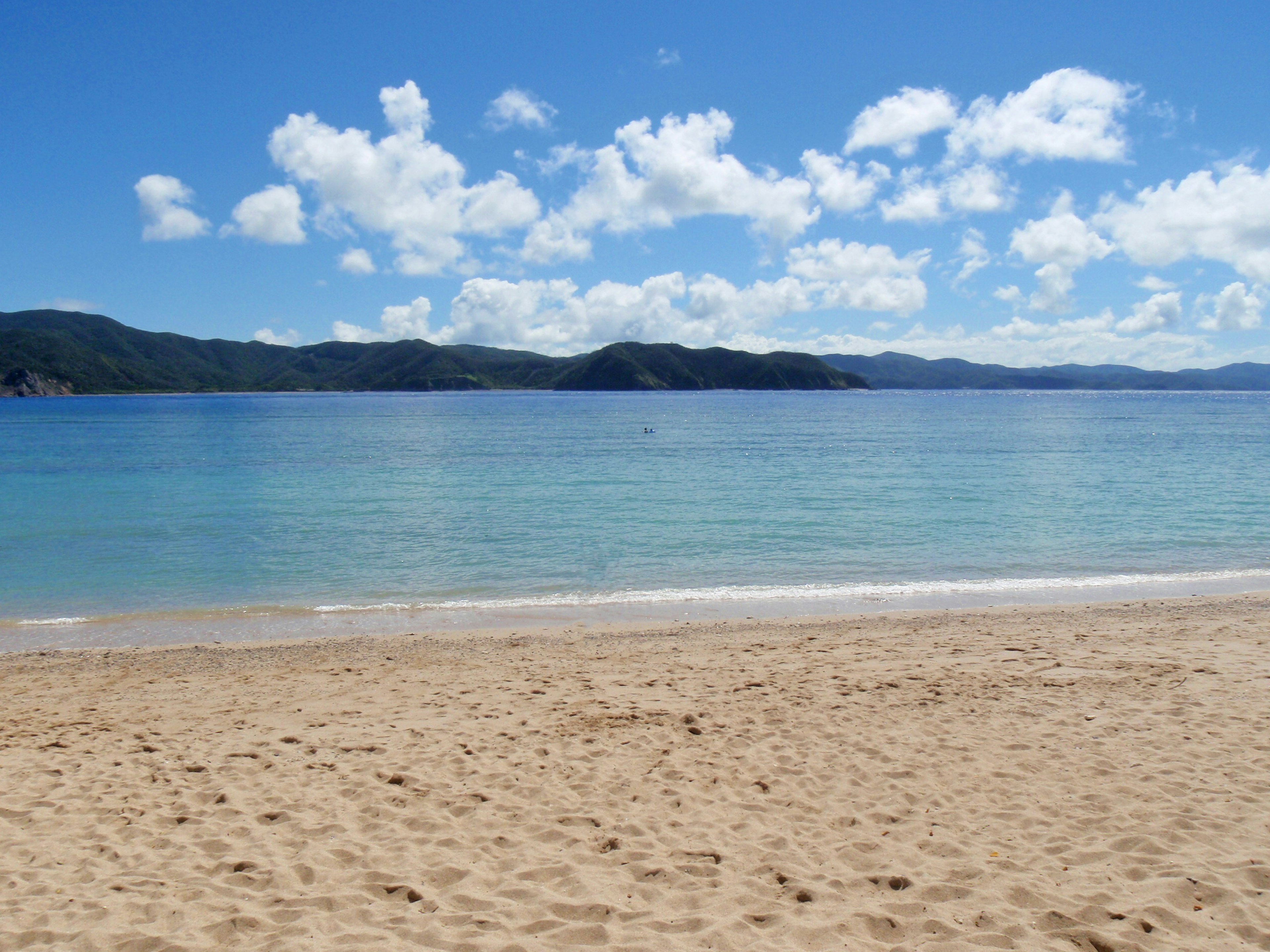 Scenic view of a beach with clear blue water and golden sand