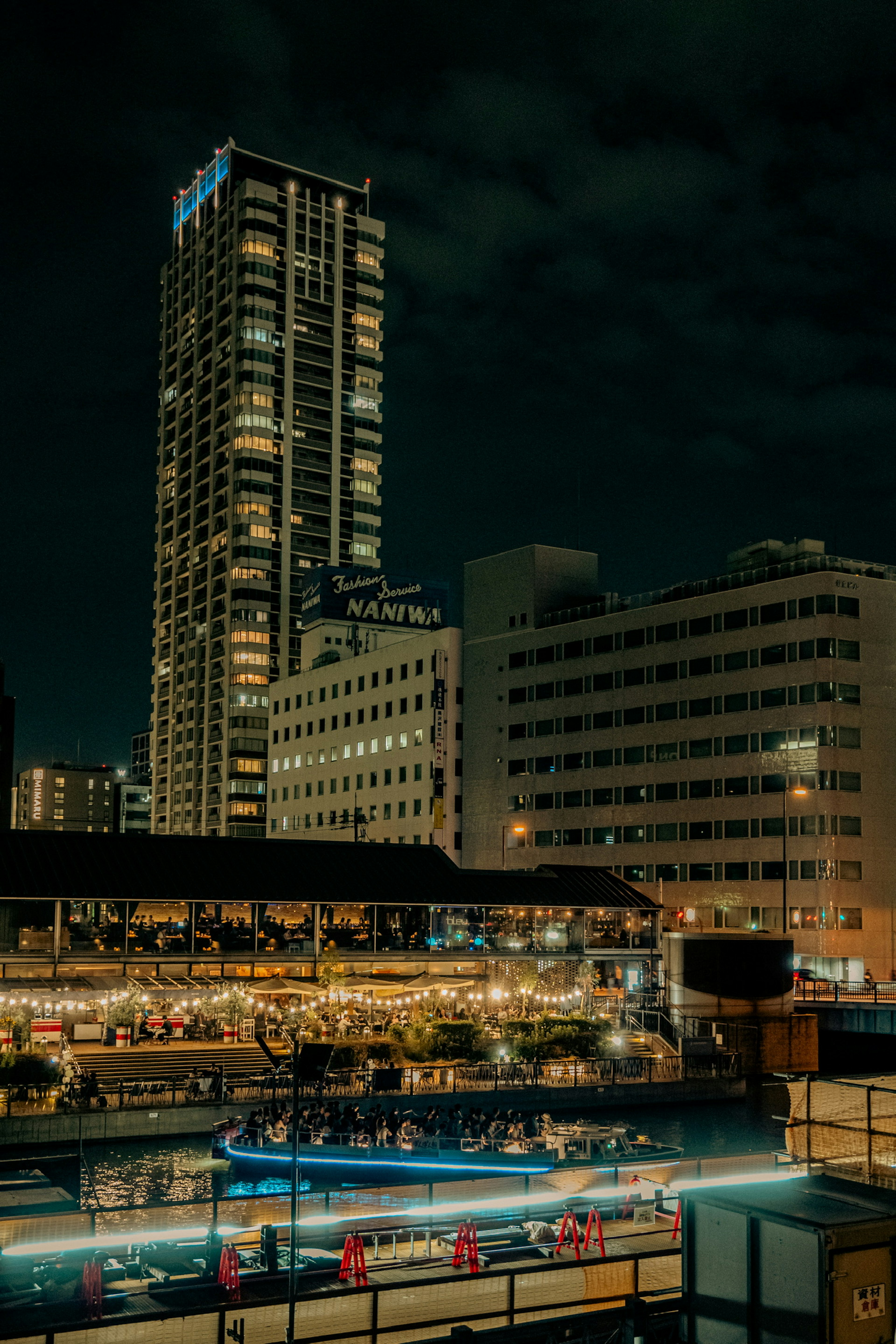 Paysage urbain nocturne avec gratte-ciel et scène de restaurant animée