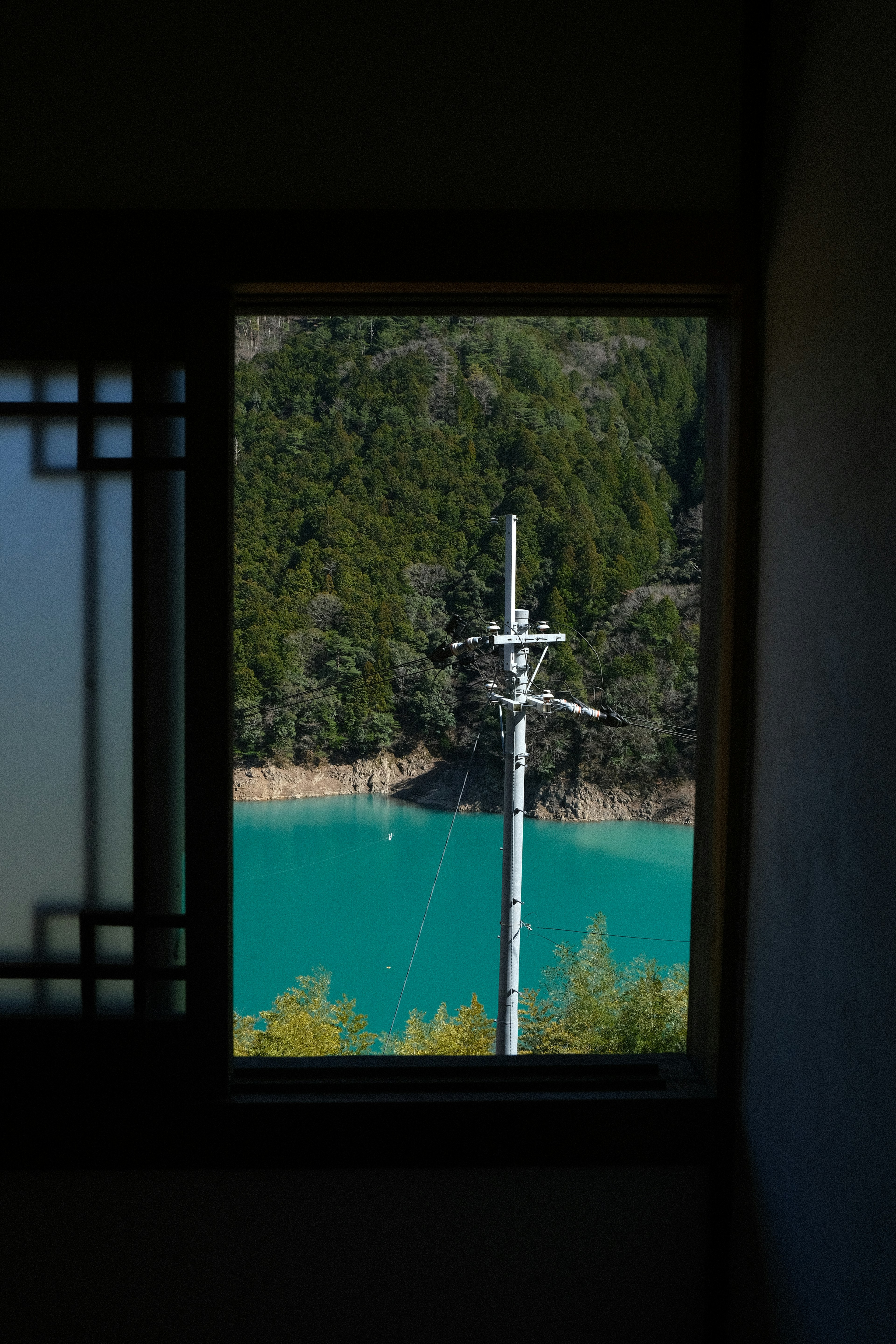 窓から見える青い湖と電柱の風景