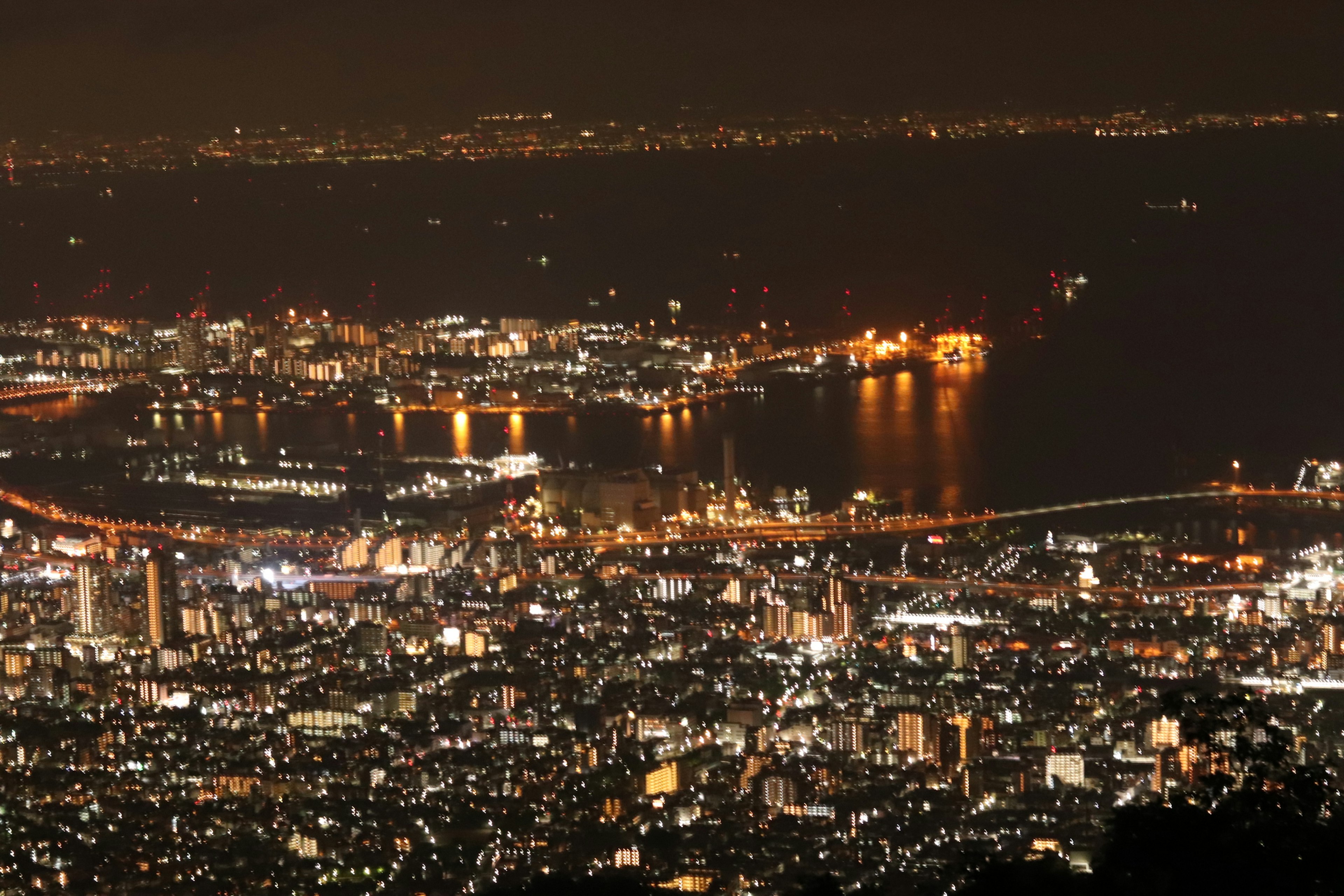 Paesaggio urbano notturno con edifici illuminati e un porto