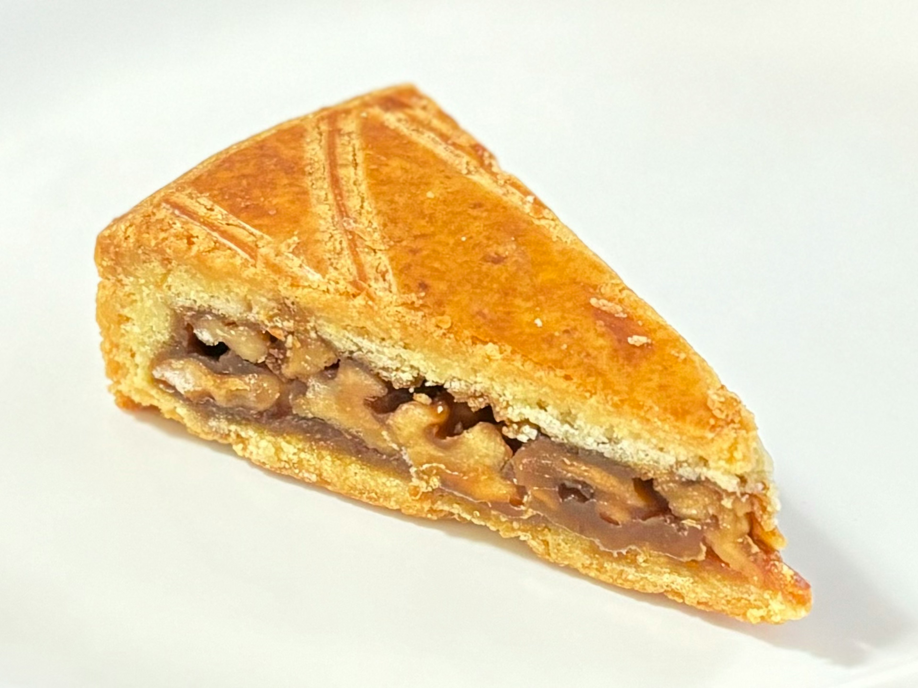 A slice of delicious apple pie with a golden crust and visible apple and nut filling