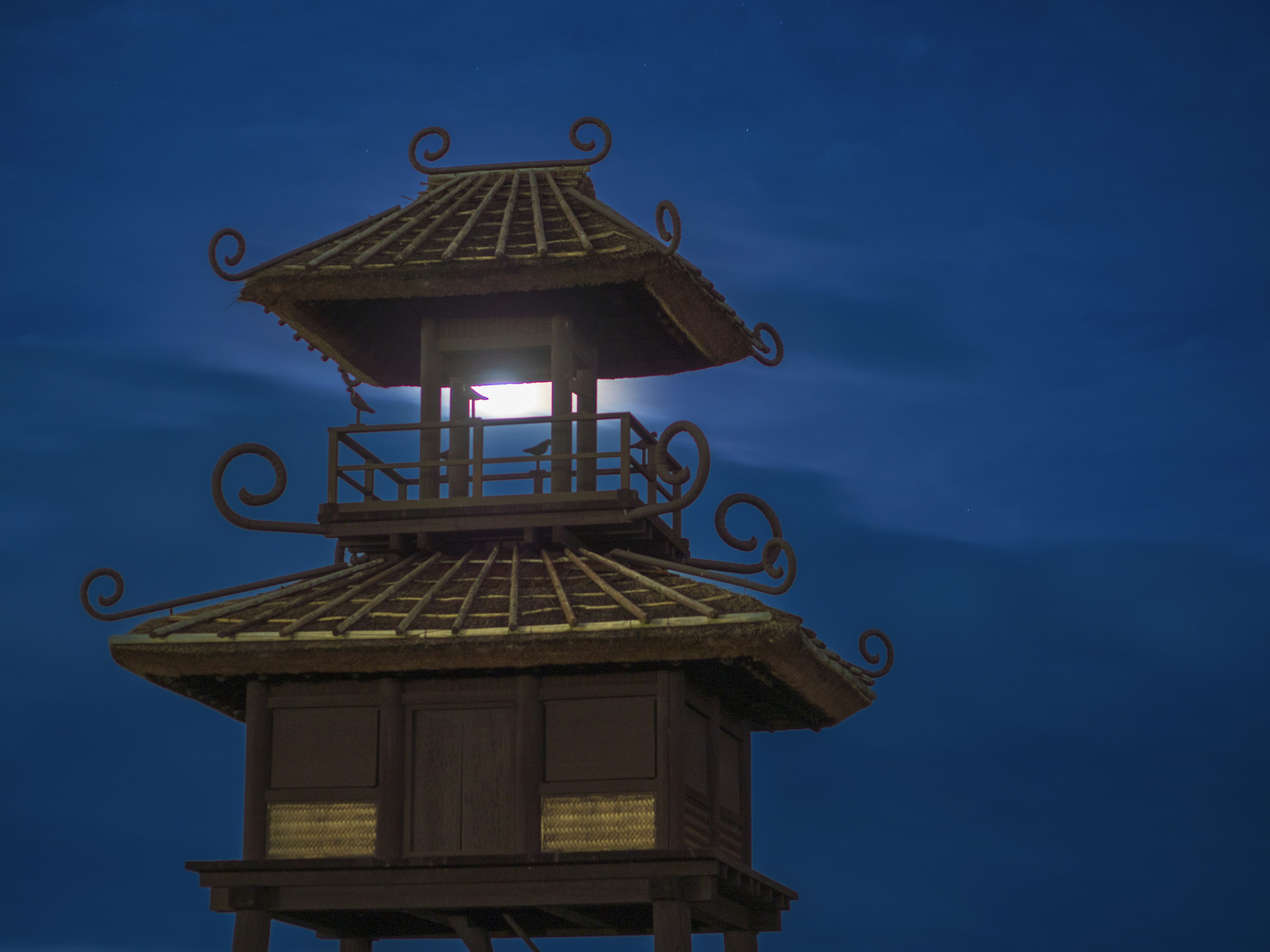 Beautiful tower structure under a blue sky with moonlight shining from within