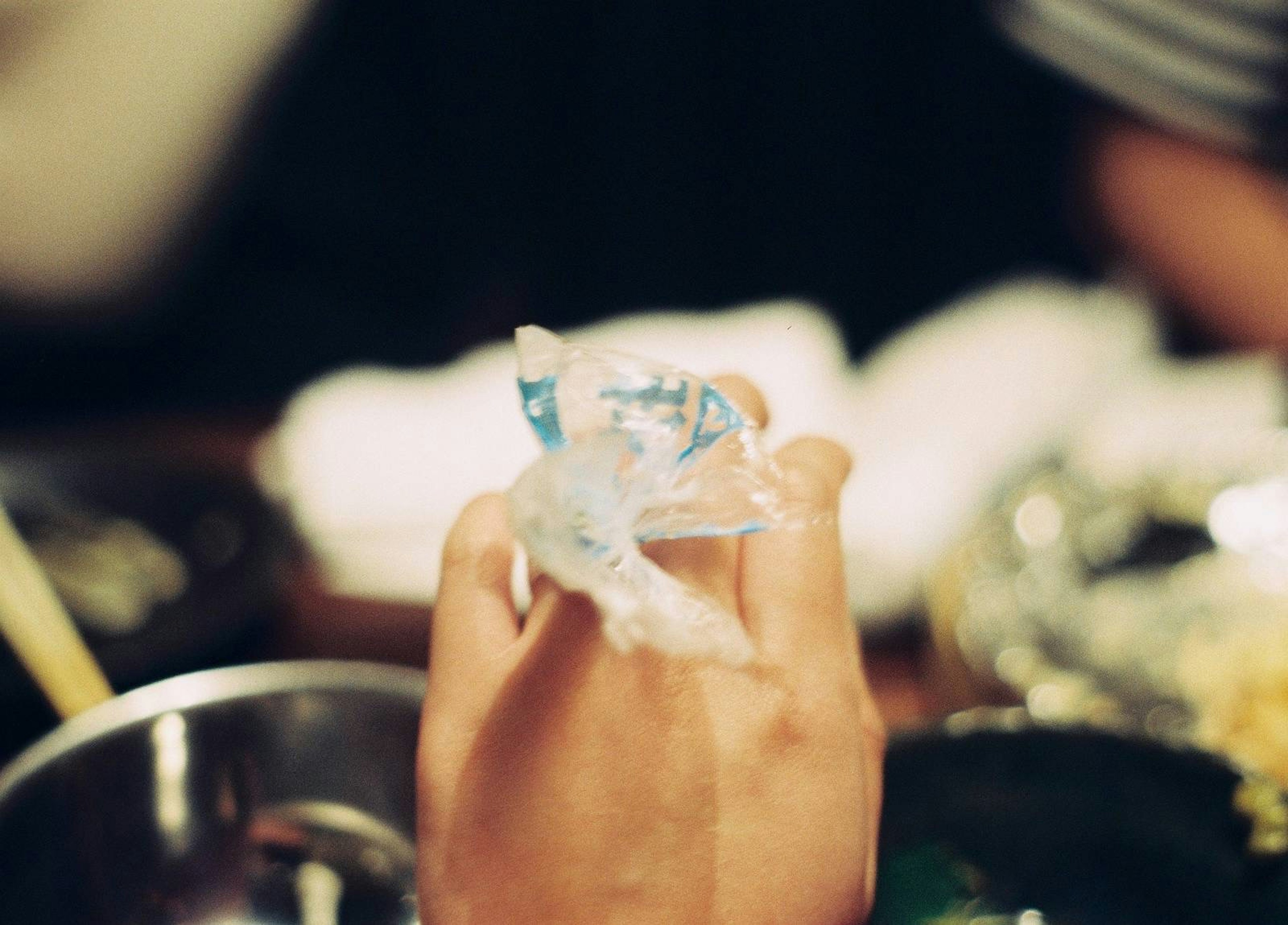 A hand holding a transparent bag with blue markings