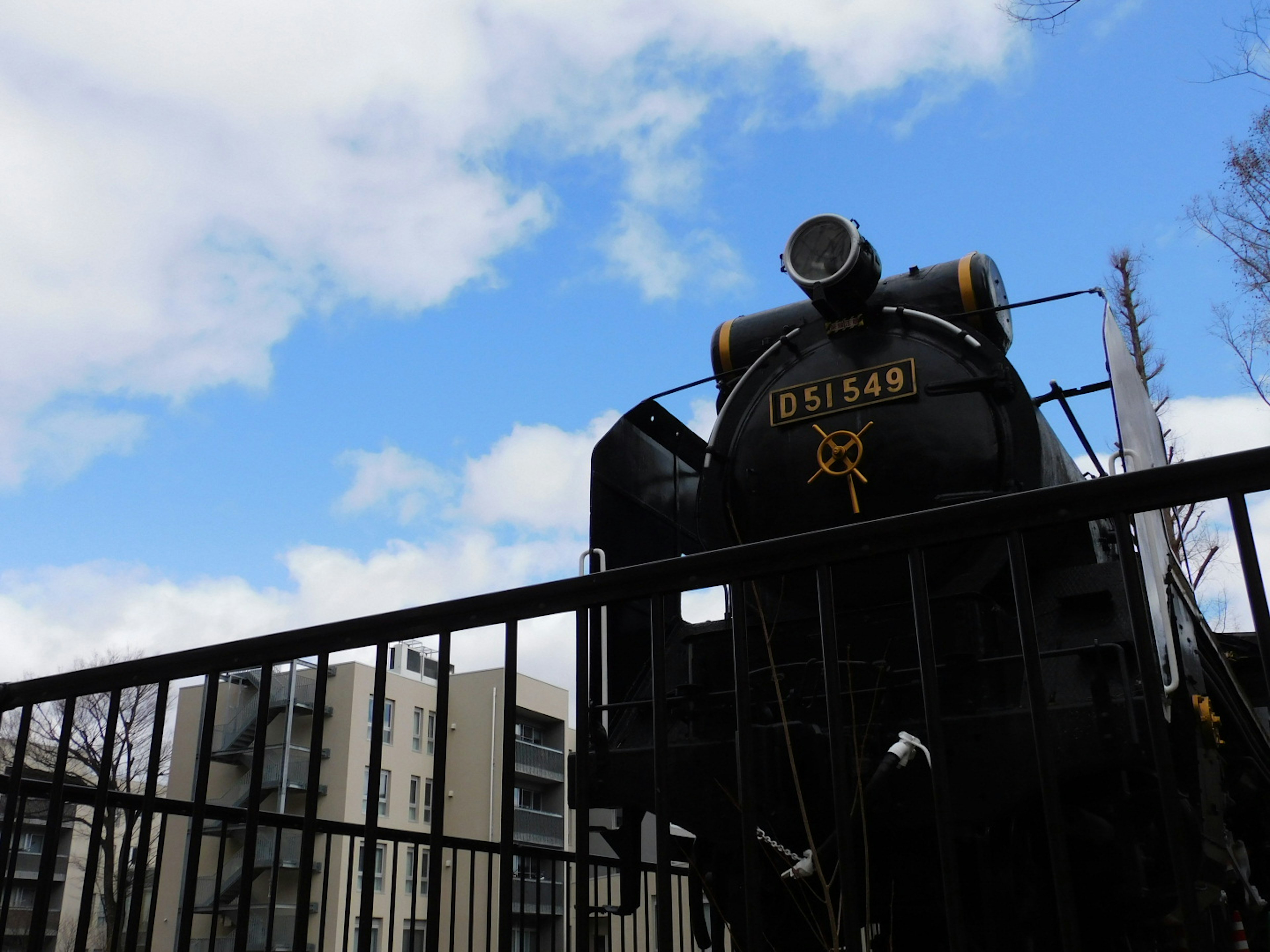 Black steam locomotive against a blue sky