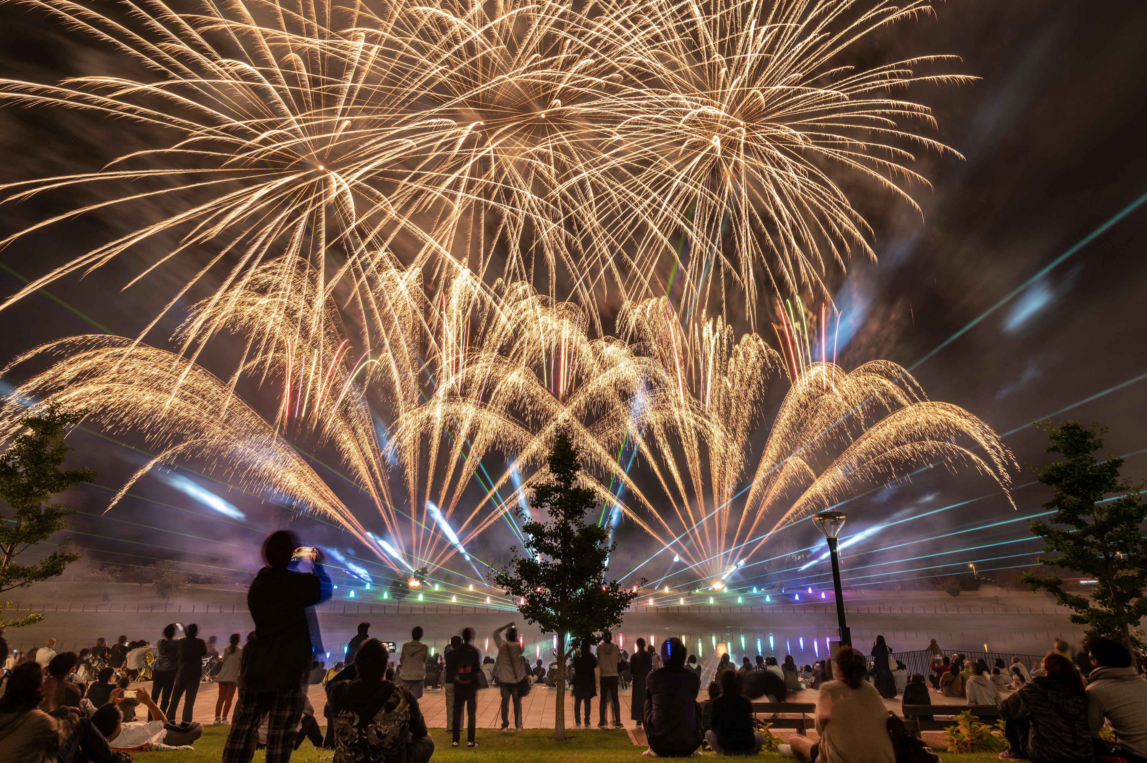 Spectacular fireworks display in the night sky with a crowd of spectators enjoying the view