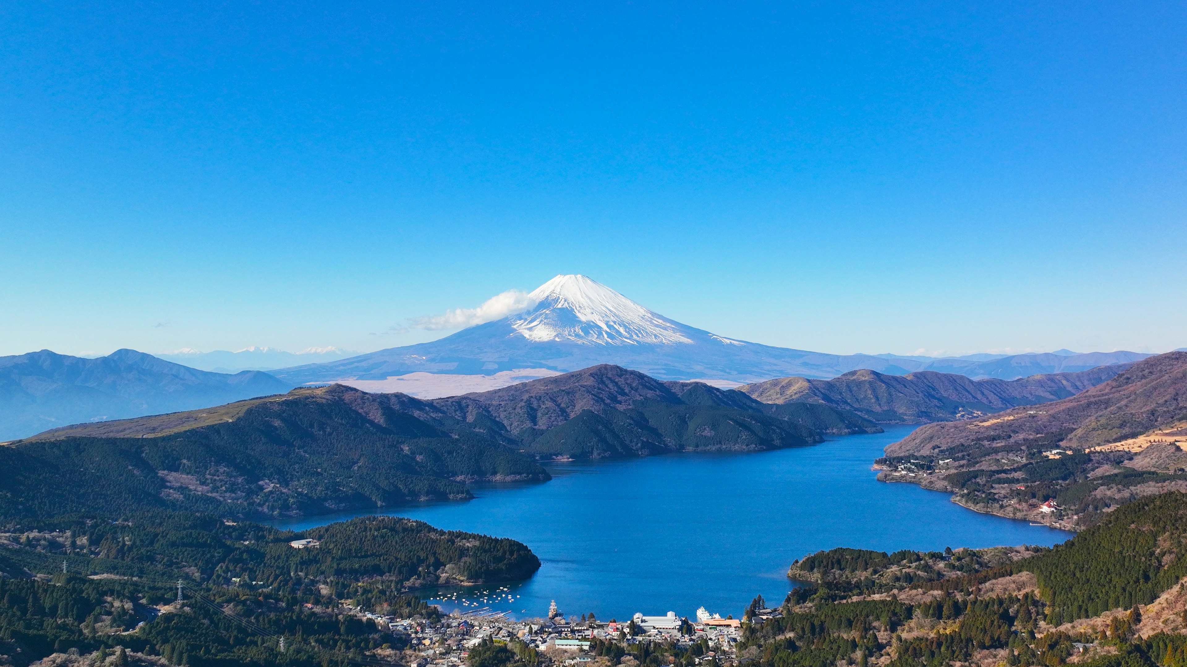 Vista escénica del lago Ashi con el monte Fuji al fondo bajo un cielo azul claro