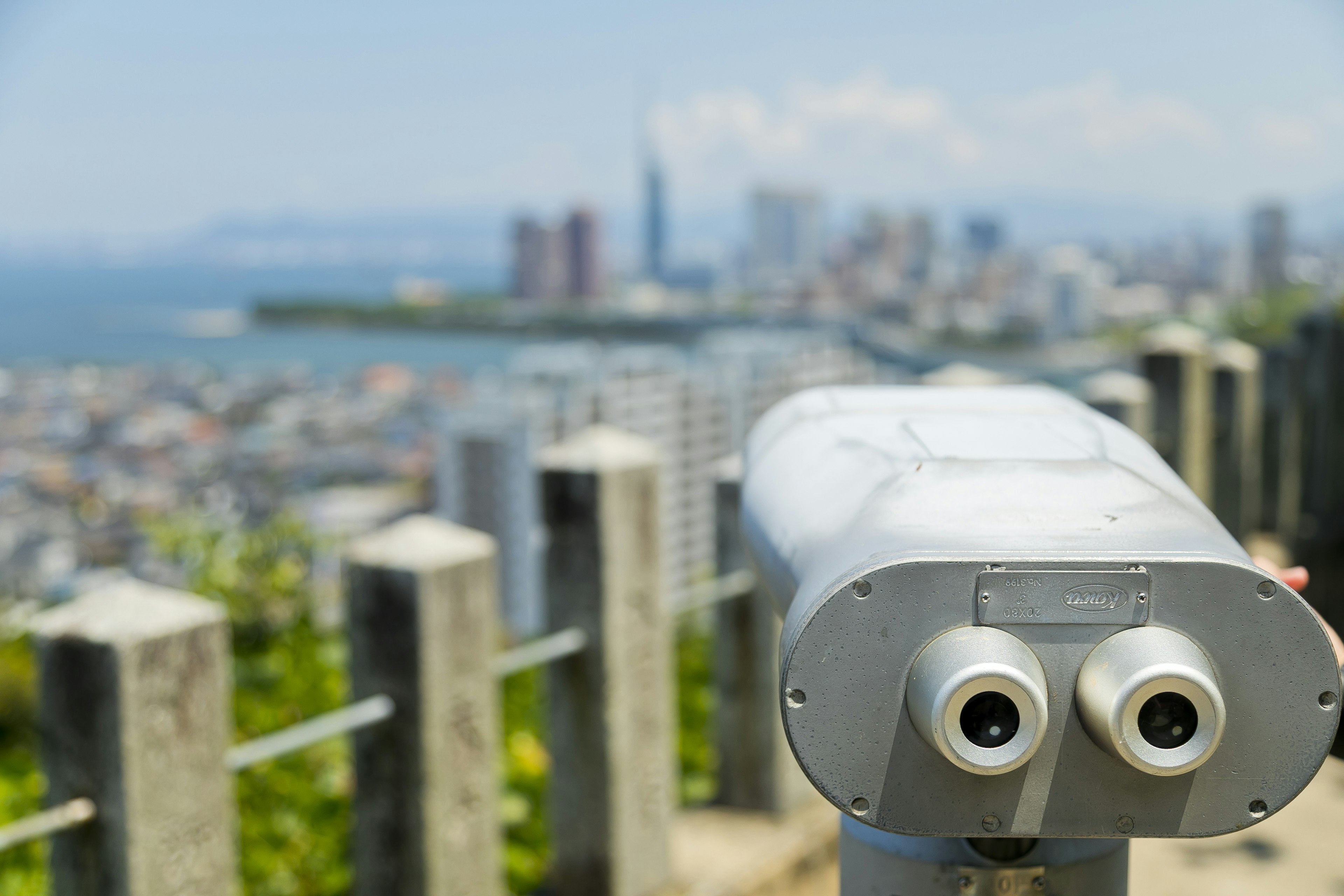 Binoculares con vista a un horizonte urbano y el océano