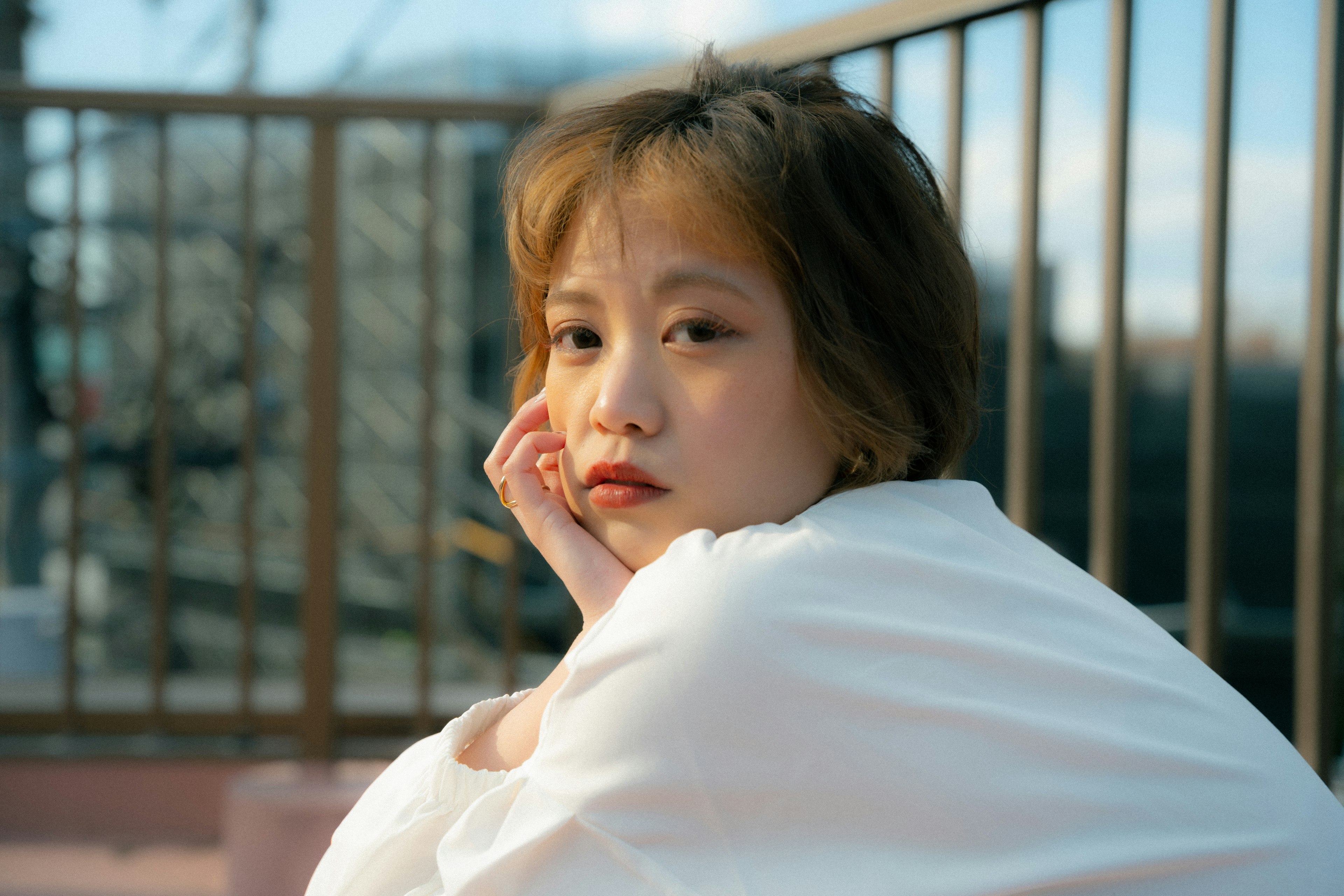 Portrait of a woman outdoors wrapped in a white cloth softly illuminated with a serene expression