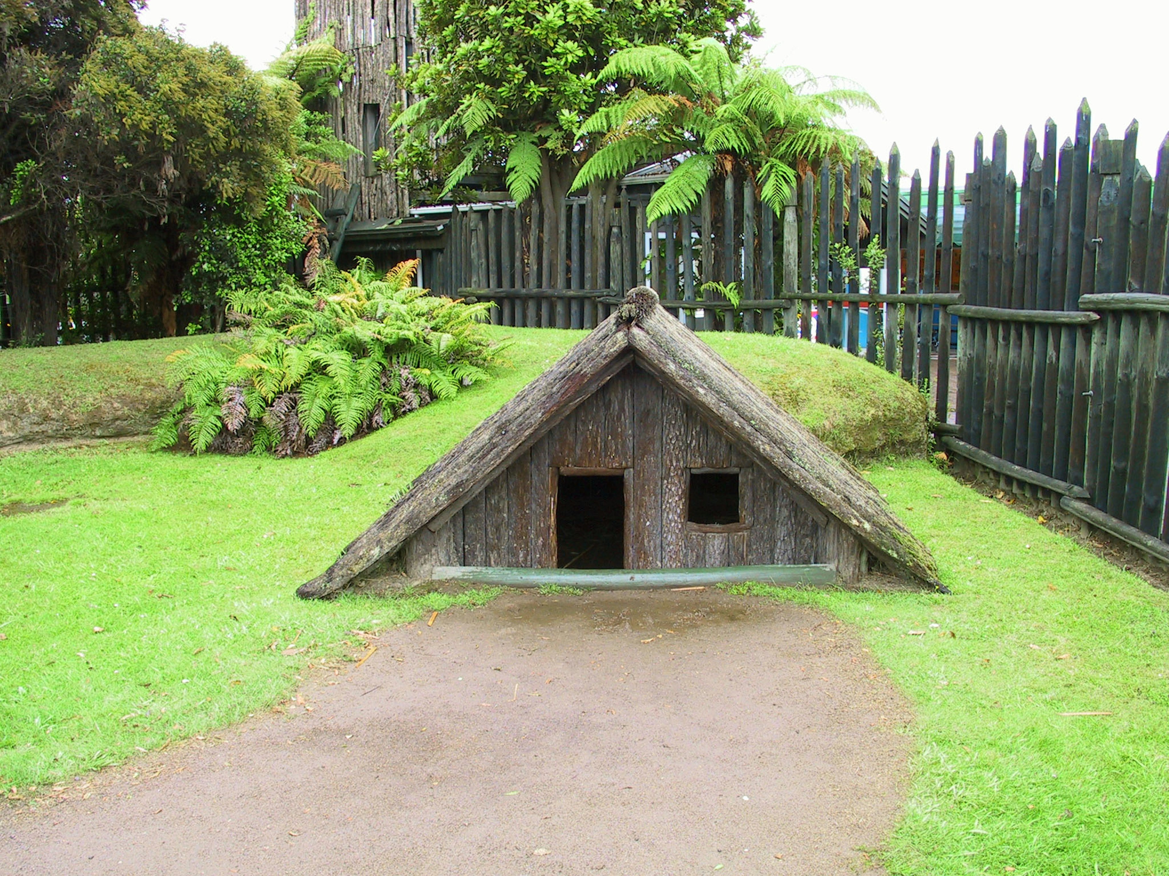 Thatched roof hut with a green garden landscape