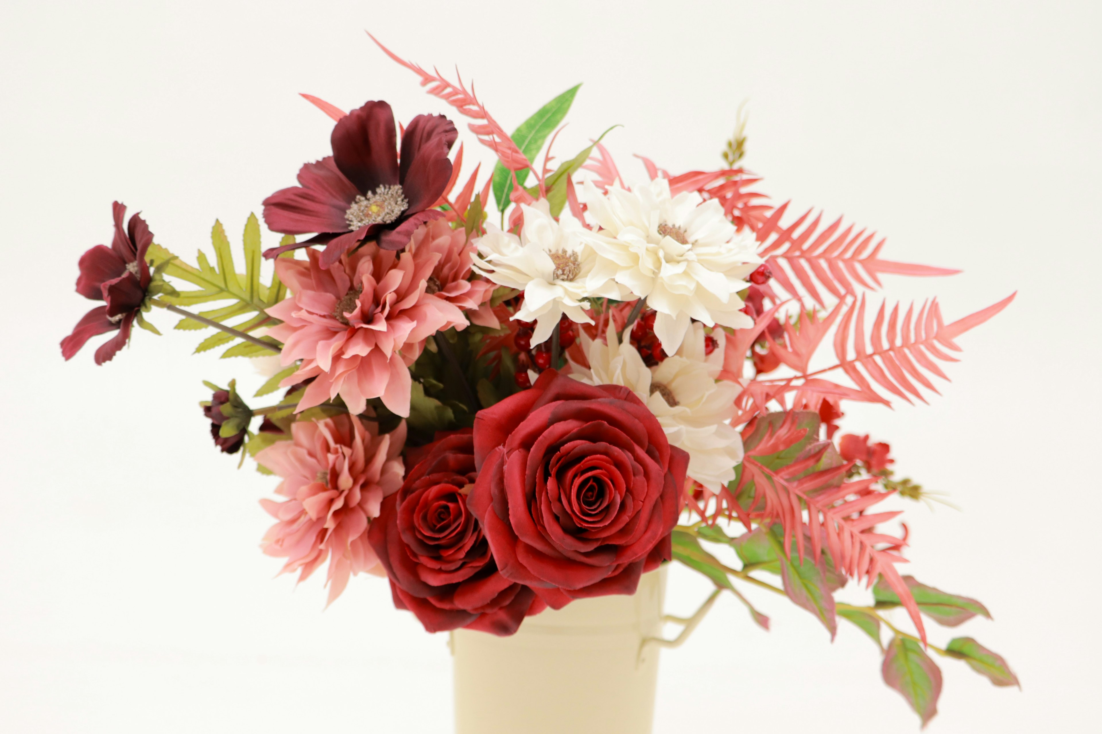 Un bouquet con rose rosse e fiori rosa disposti con cura