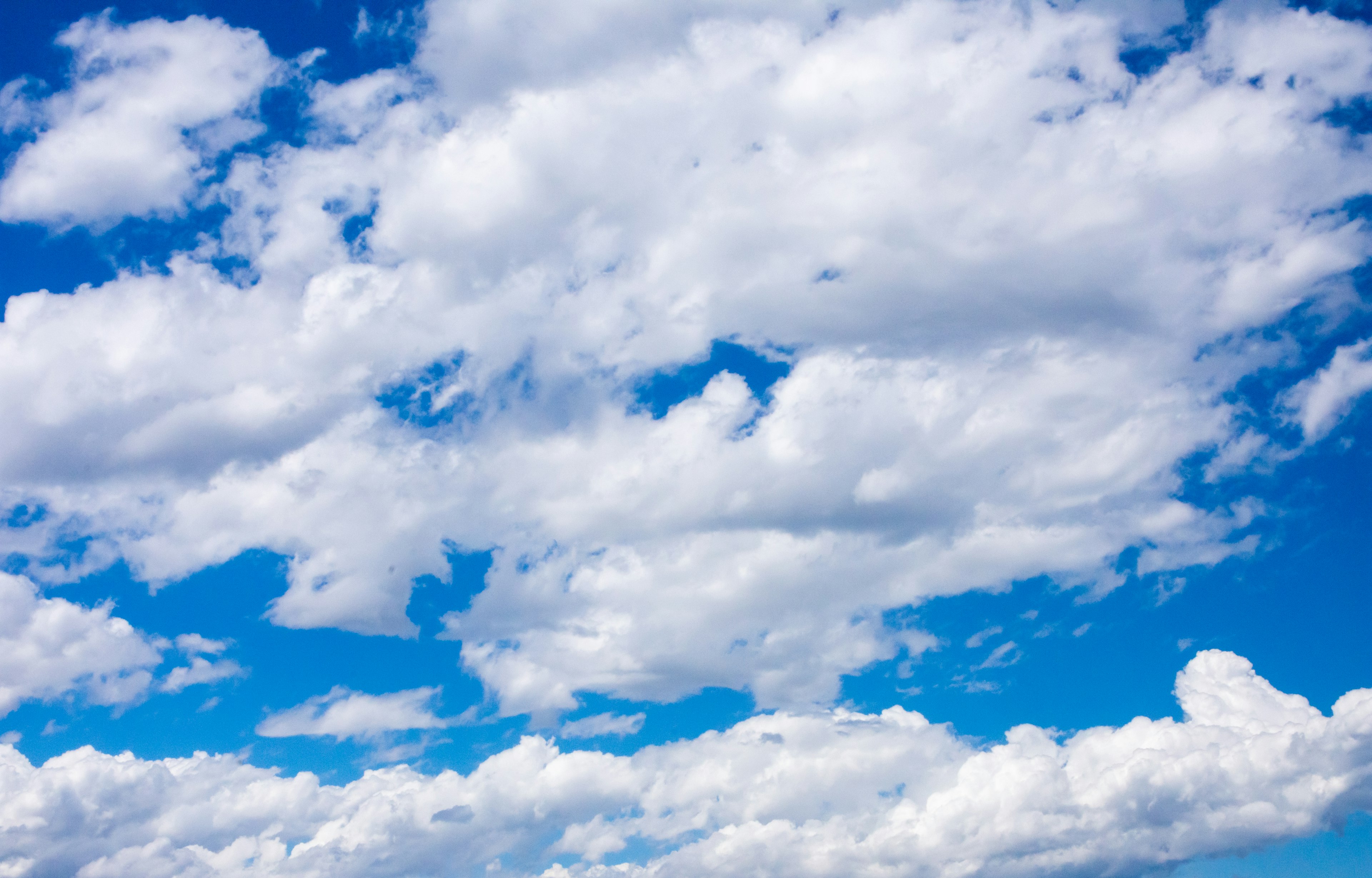 Pemandangan awan putih yang tersebar di langit biru