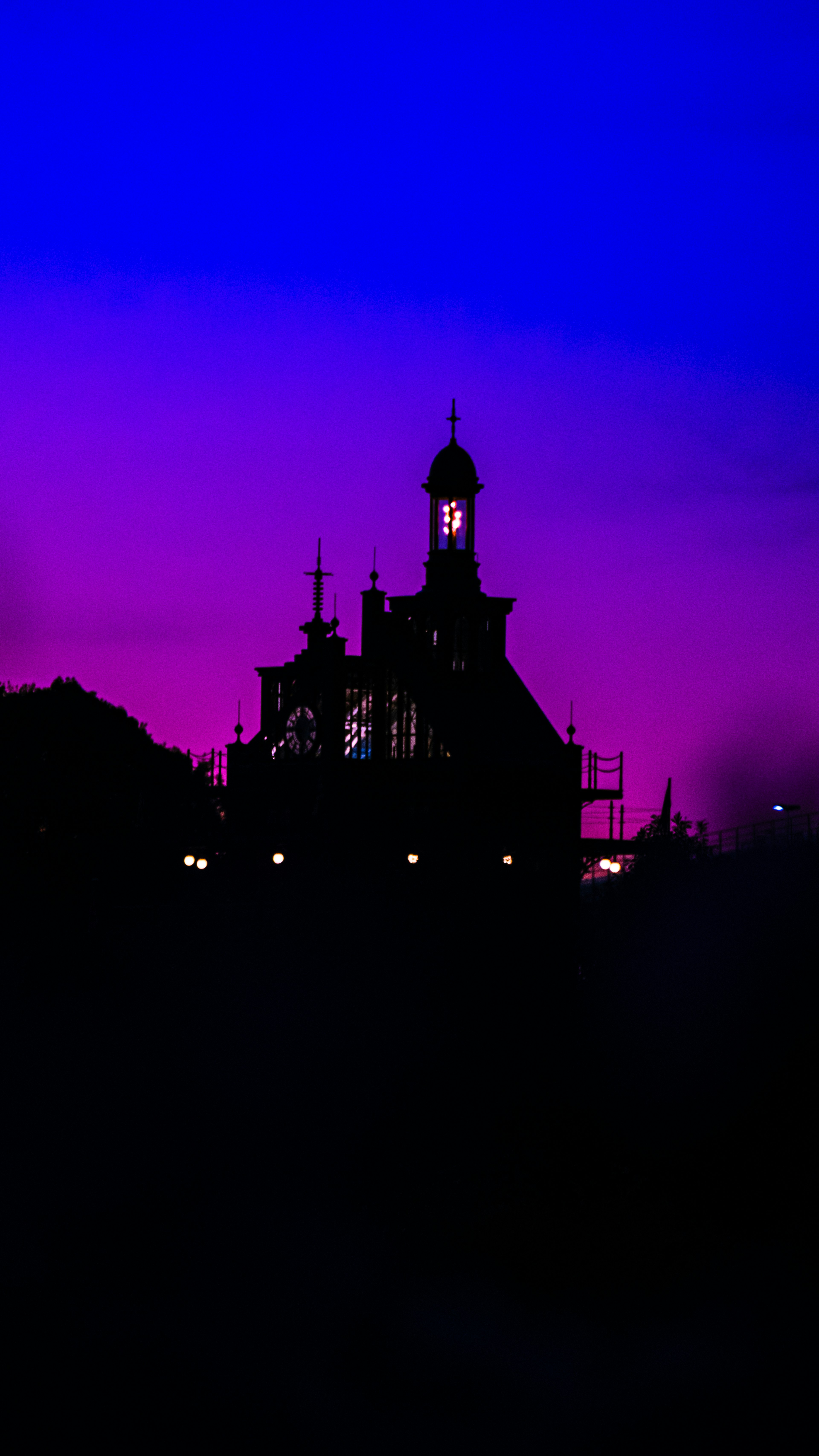 Silhouette of an old building against a gradient of purple and blue night sky