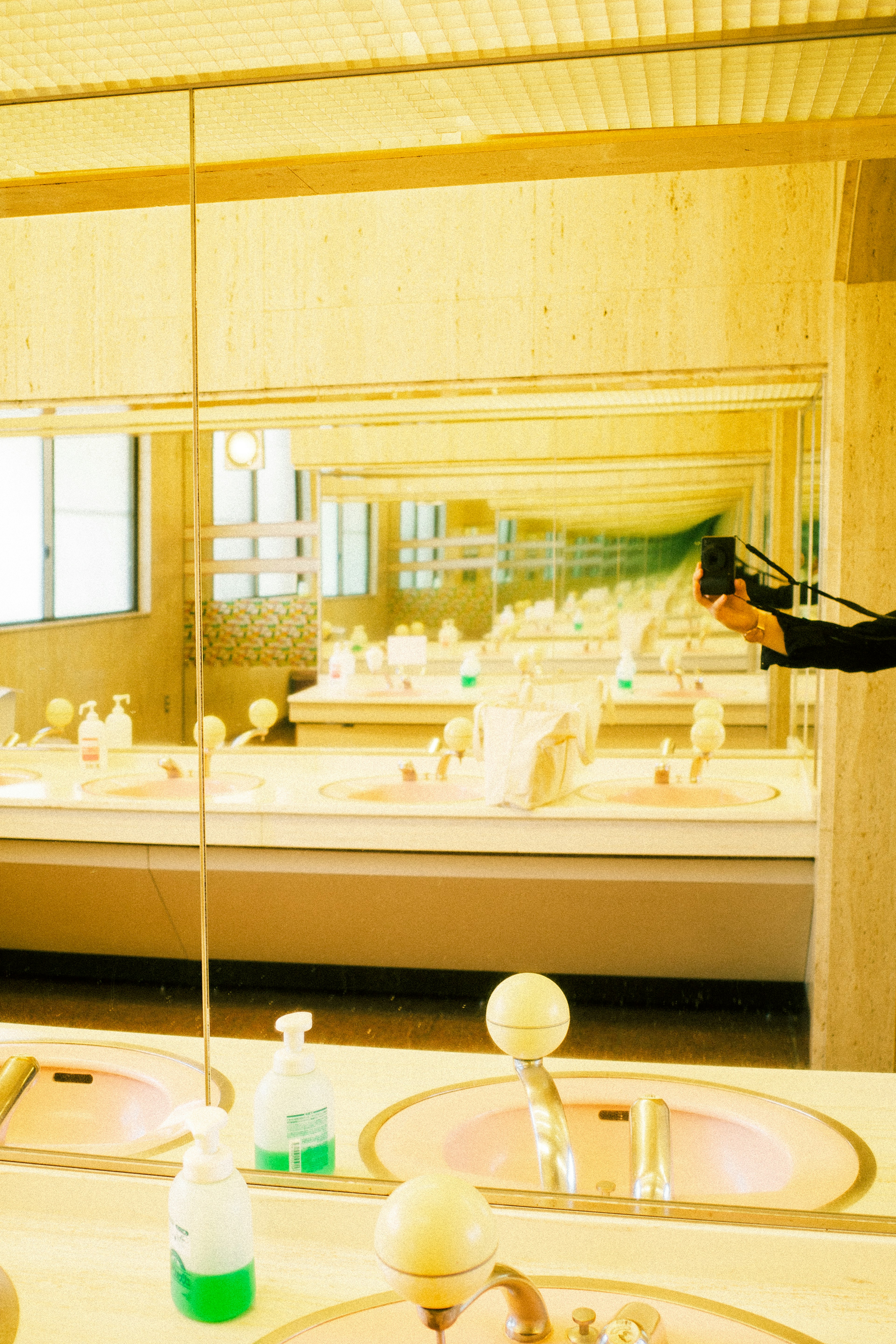 Salle de bain à ton jaune vif avec des reflets dans le miroir et des détails de lavabo