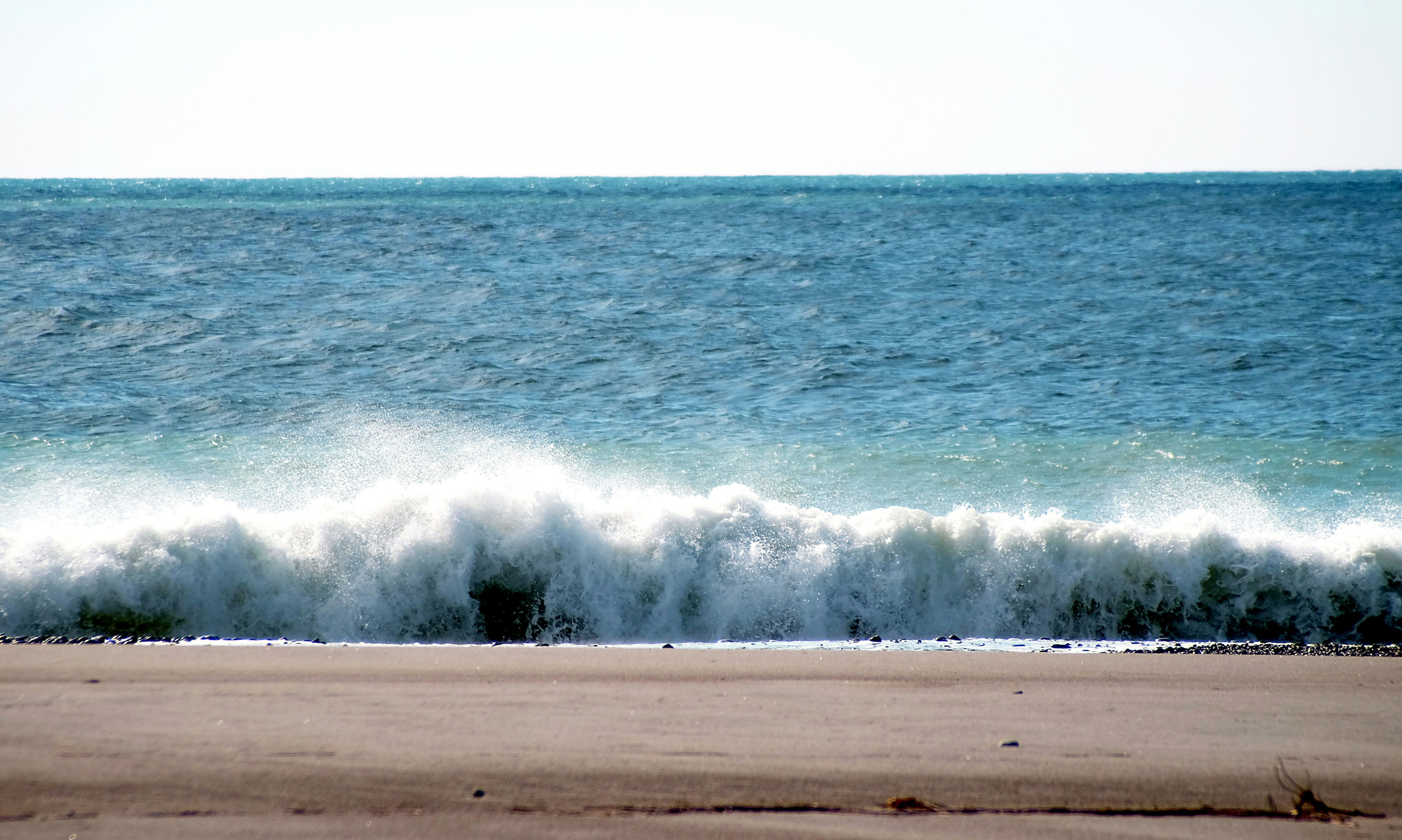 Olas tranquilas del océano rompiendo en una playa de arena