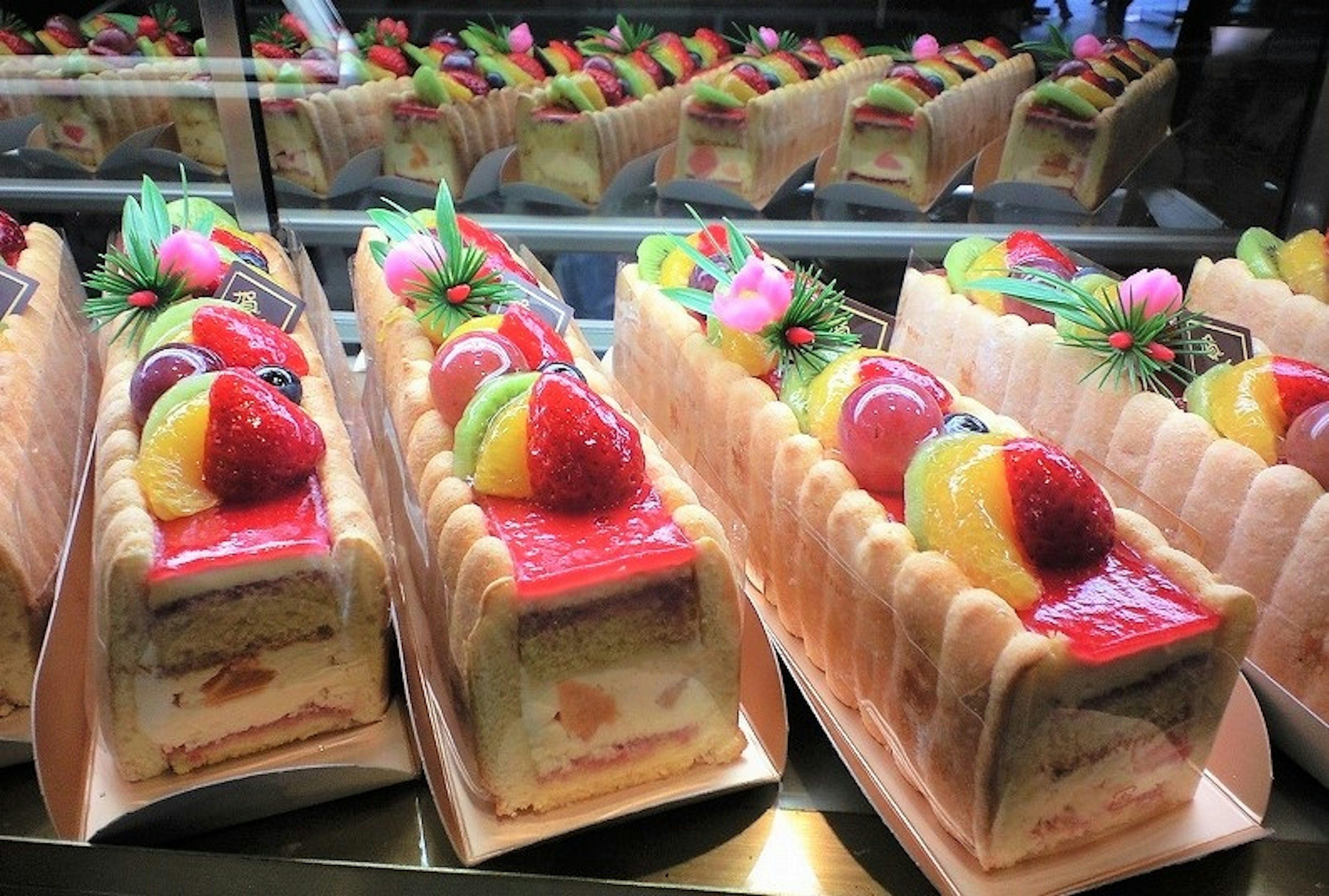 Una vitrina de hermosos pasteles de frutas dispuestos en fila