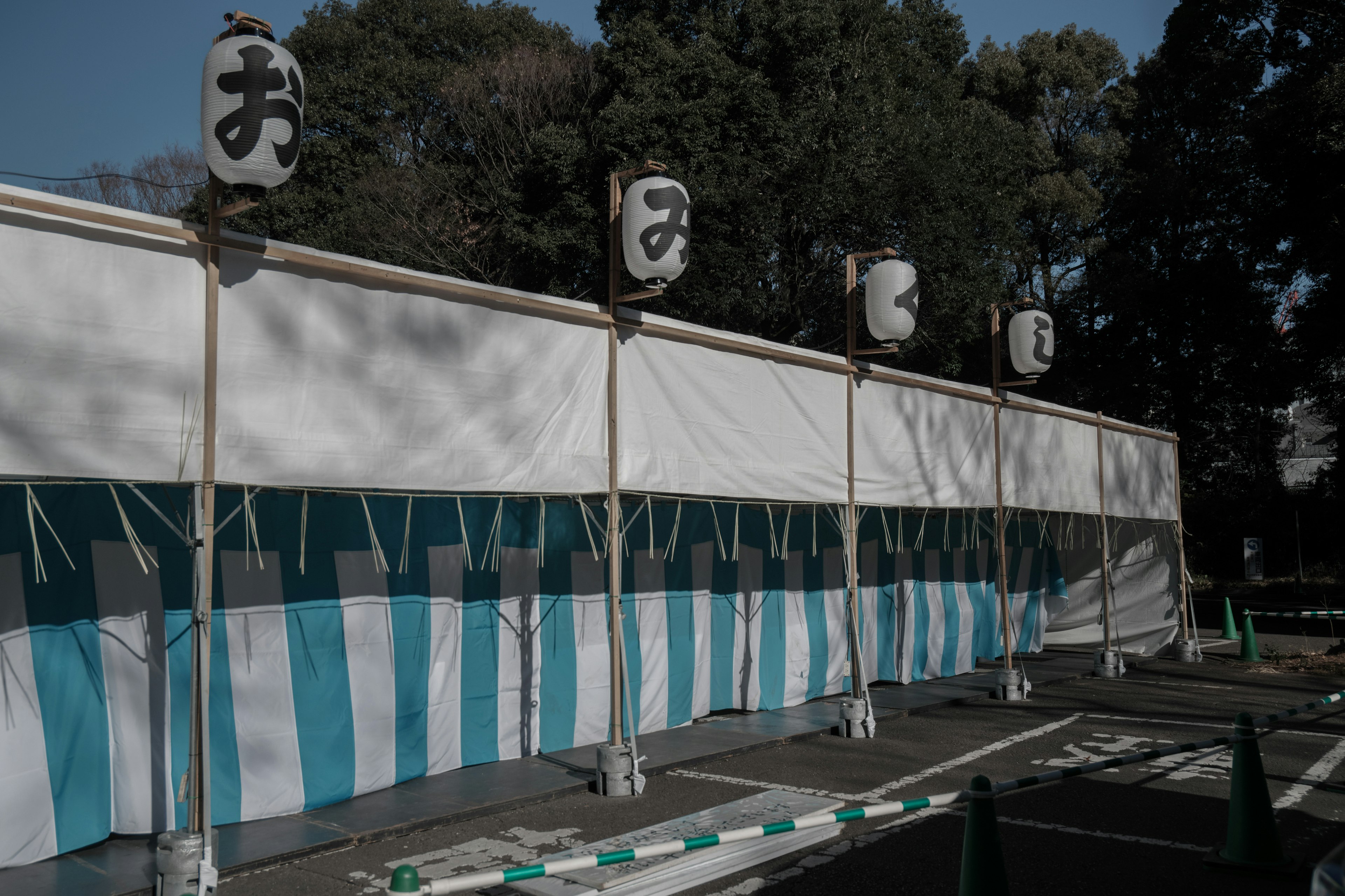 A scene with blue and white striped tent and hanging lanterns