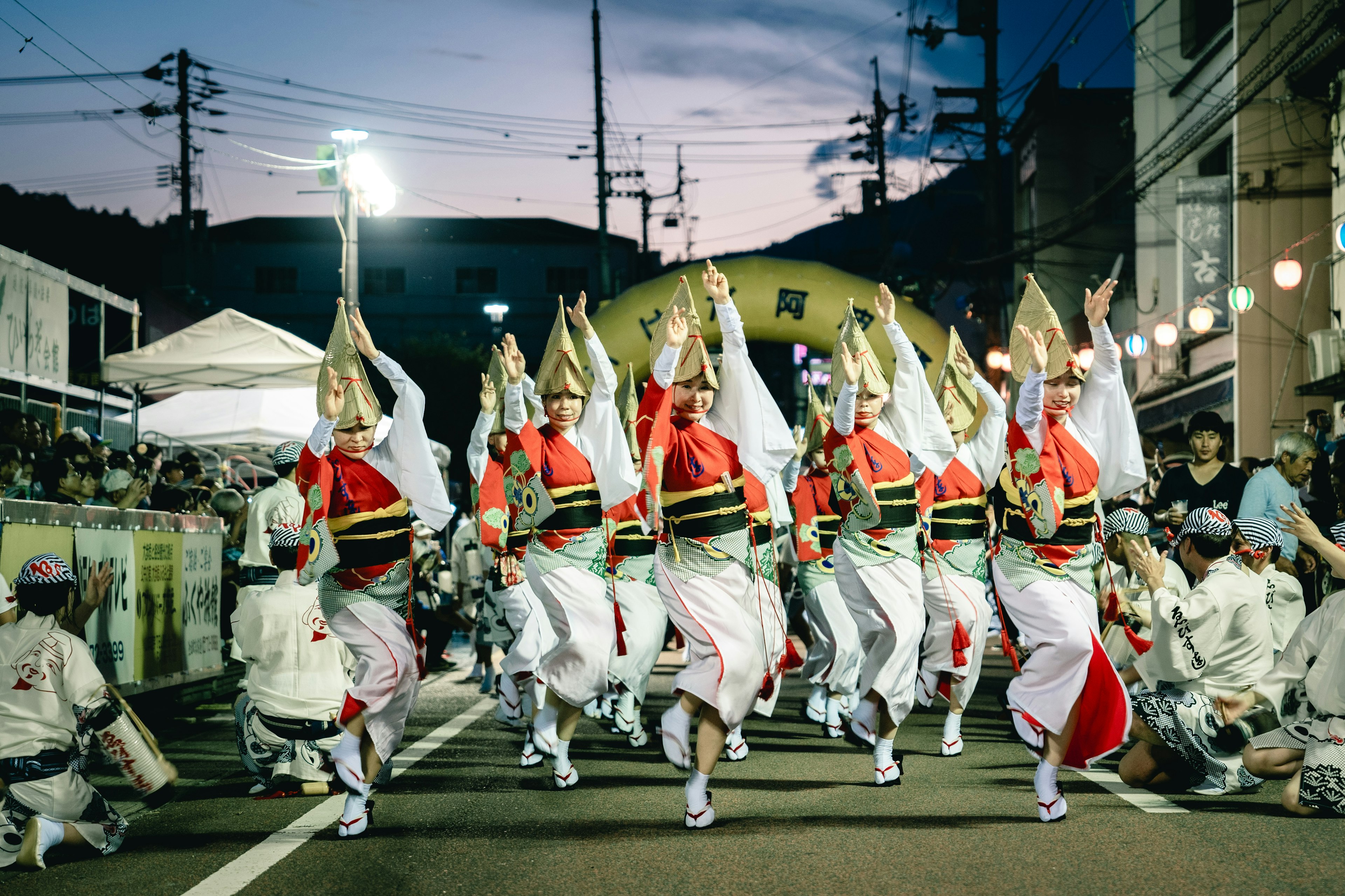 นักเต้นในชุดญี่ปุ่นดั้งเดิมแสดงในงานเทศกาลด้วยชุดสีแดงและขาว