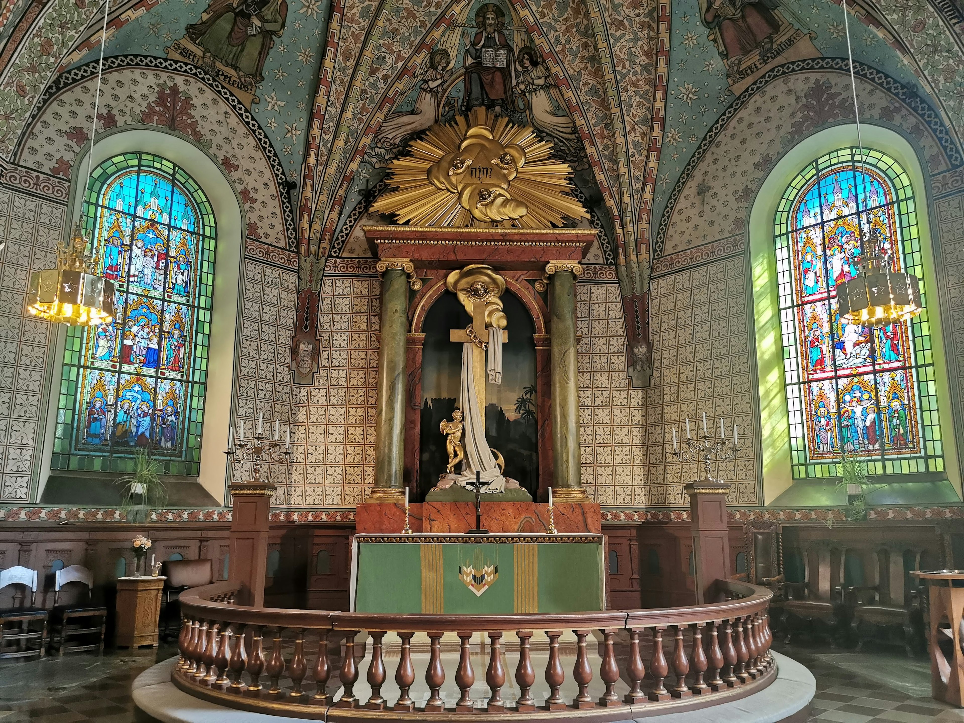 Innenraum einer Kirche mit schönen Buntglasfenstern und dekorativer Decke