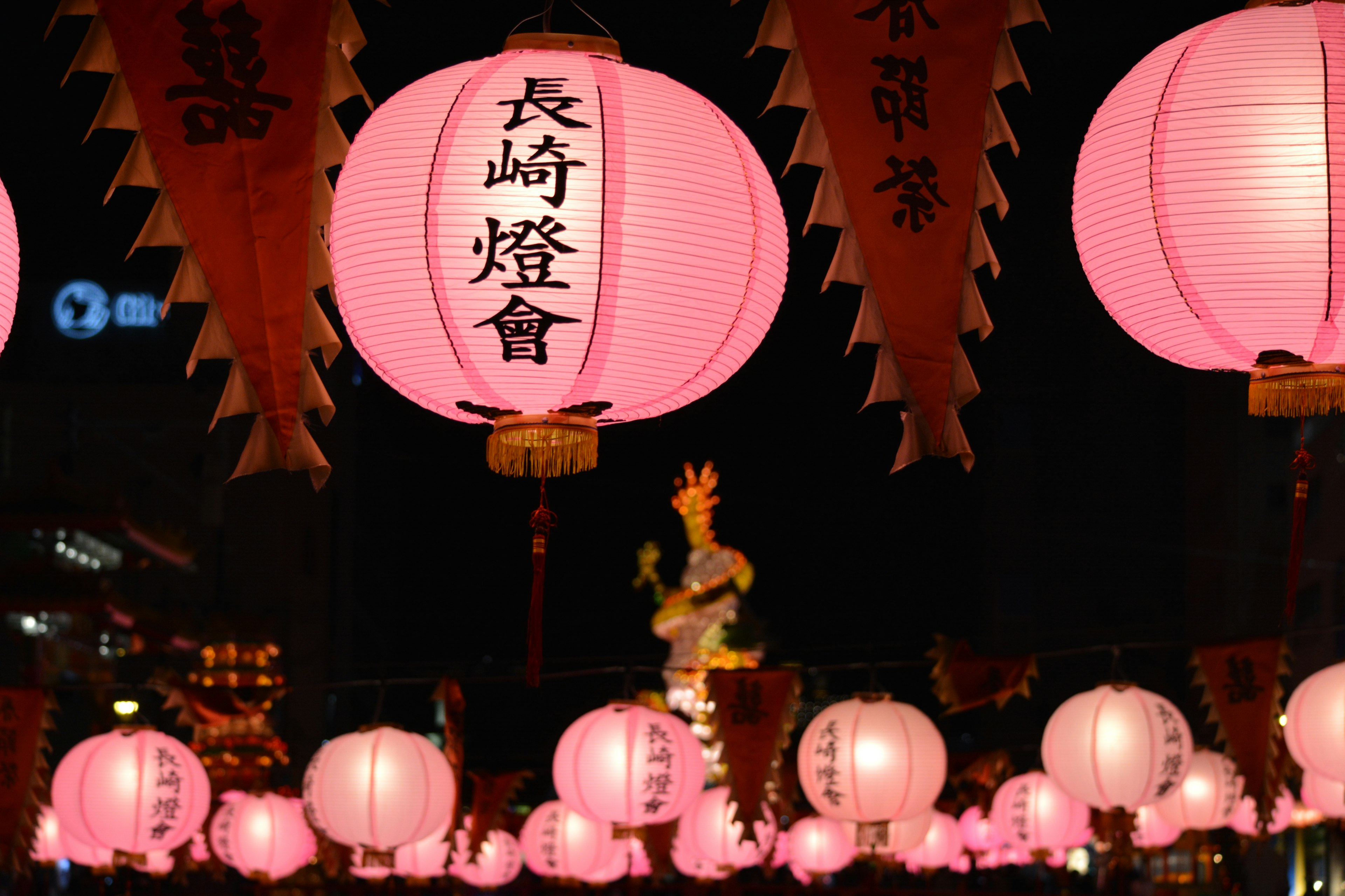 Pink lanterns glowing at night with festival decorations