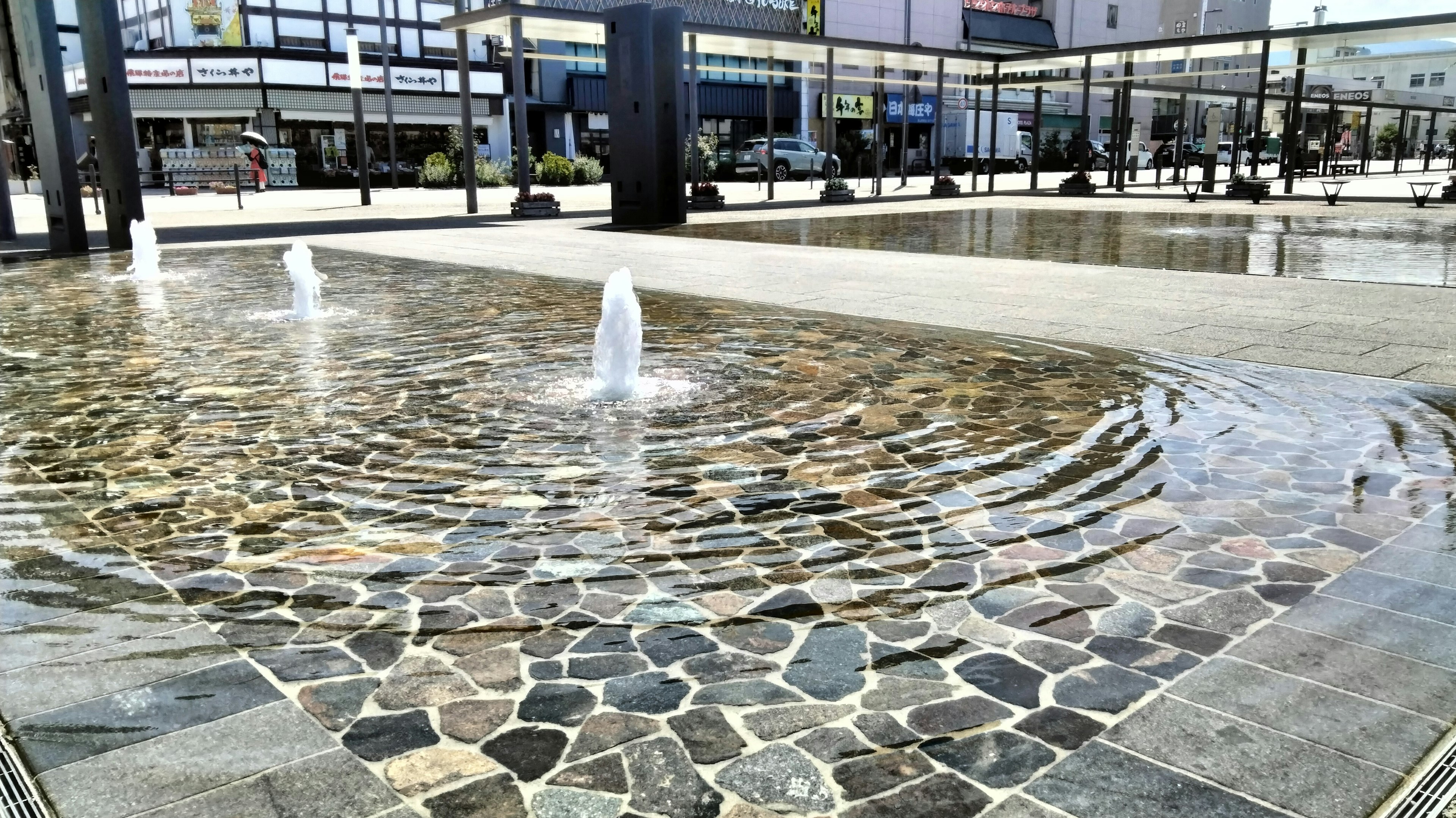 Plaza moderna con fuente de piedra y características de agua