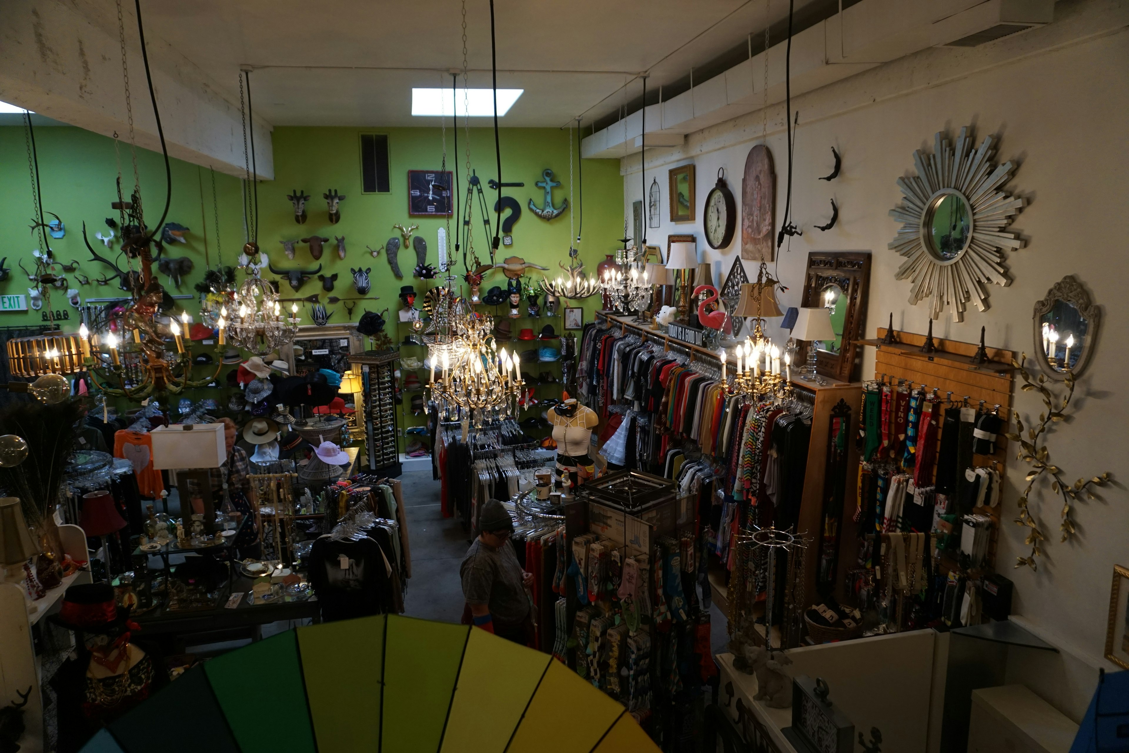 Vue d'ensemble d'un intérieur de magasin coloré avec des lumières suspendues des murs verts et divers objets décoratifs