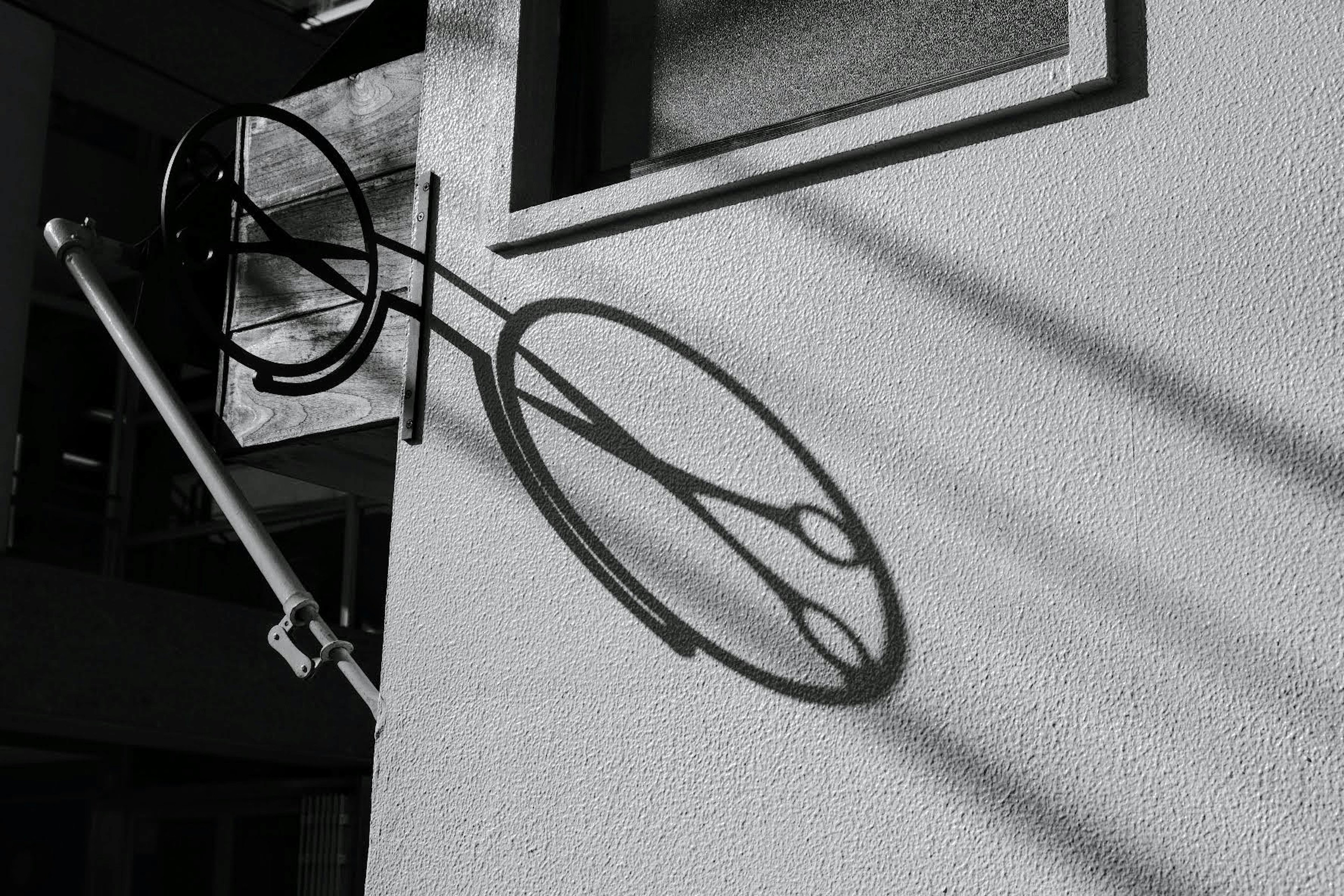 Ombre unique et structure métallique circulaire sur un mur noir et blanc