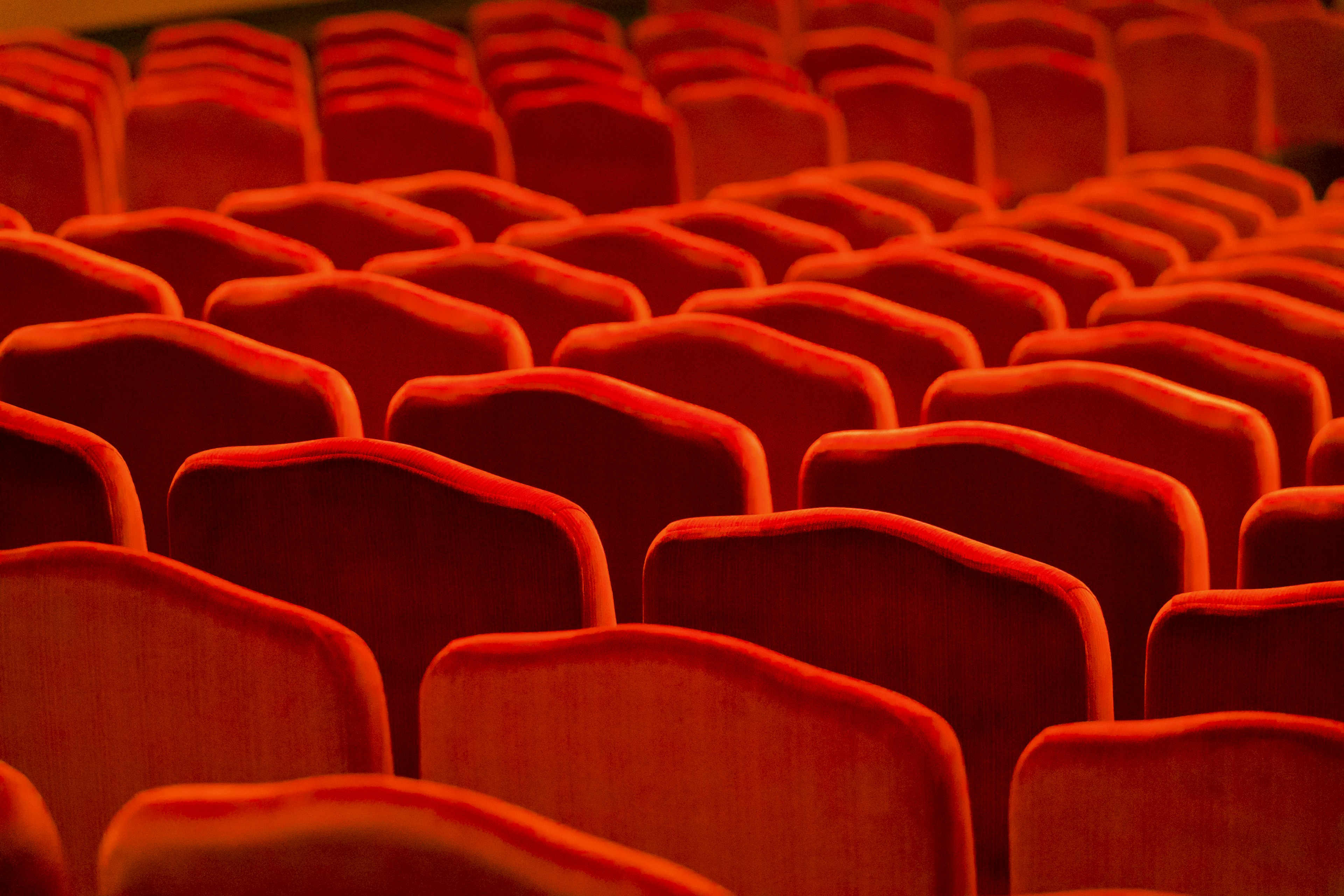 Rows of red theater seats with soft upholstery