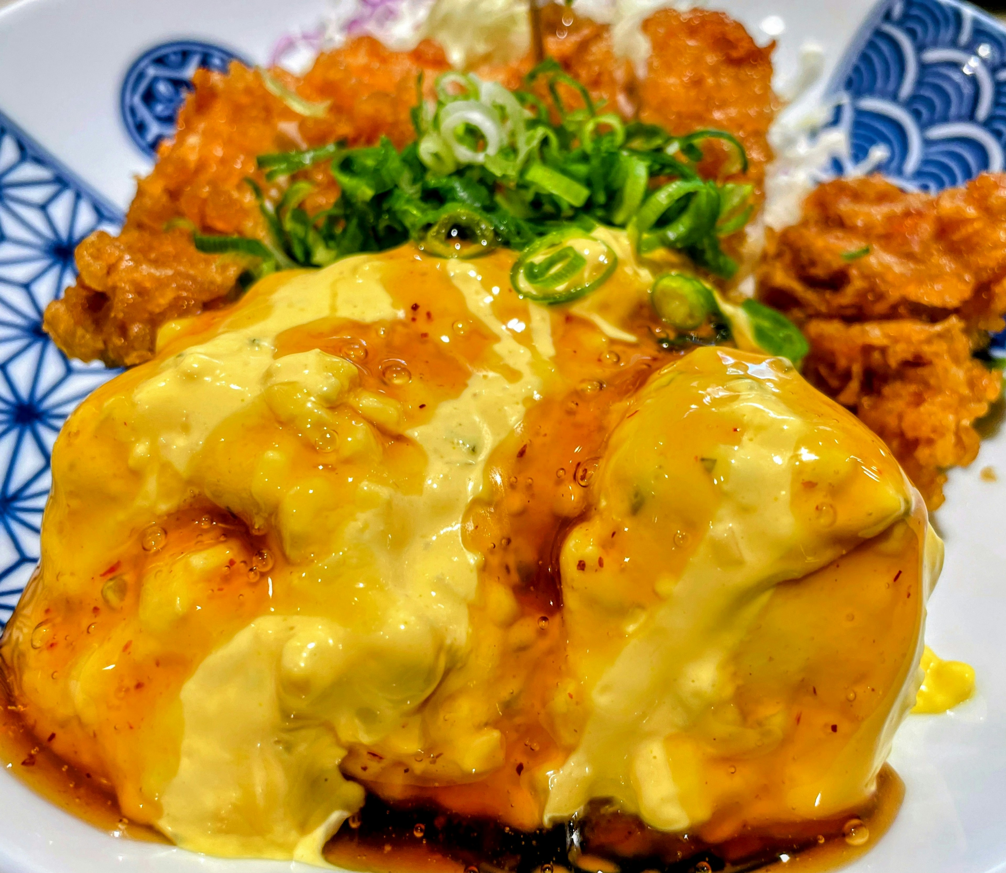 Omelette rice topped with sauce and fried chicken on the side