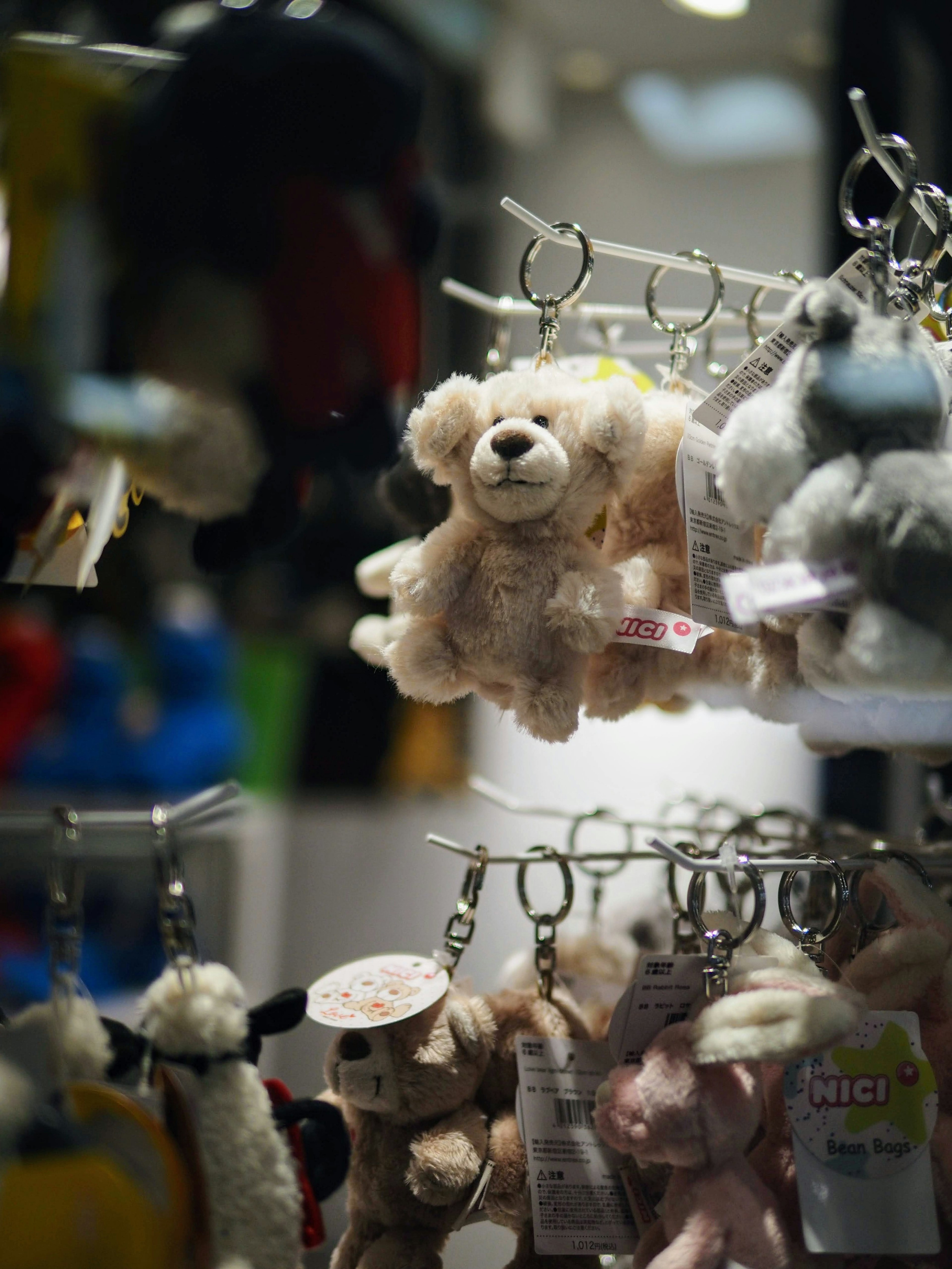 Keychains of plush toys hanging in a display